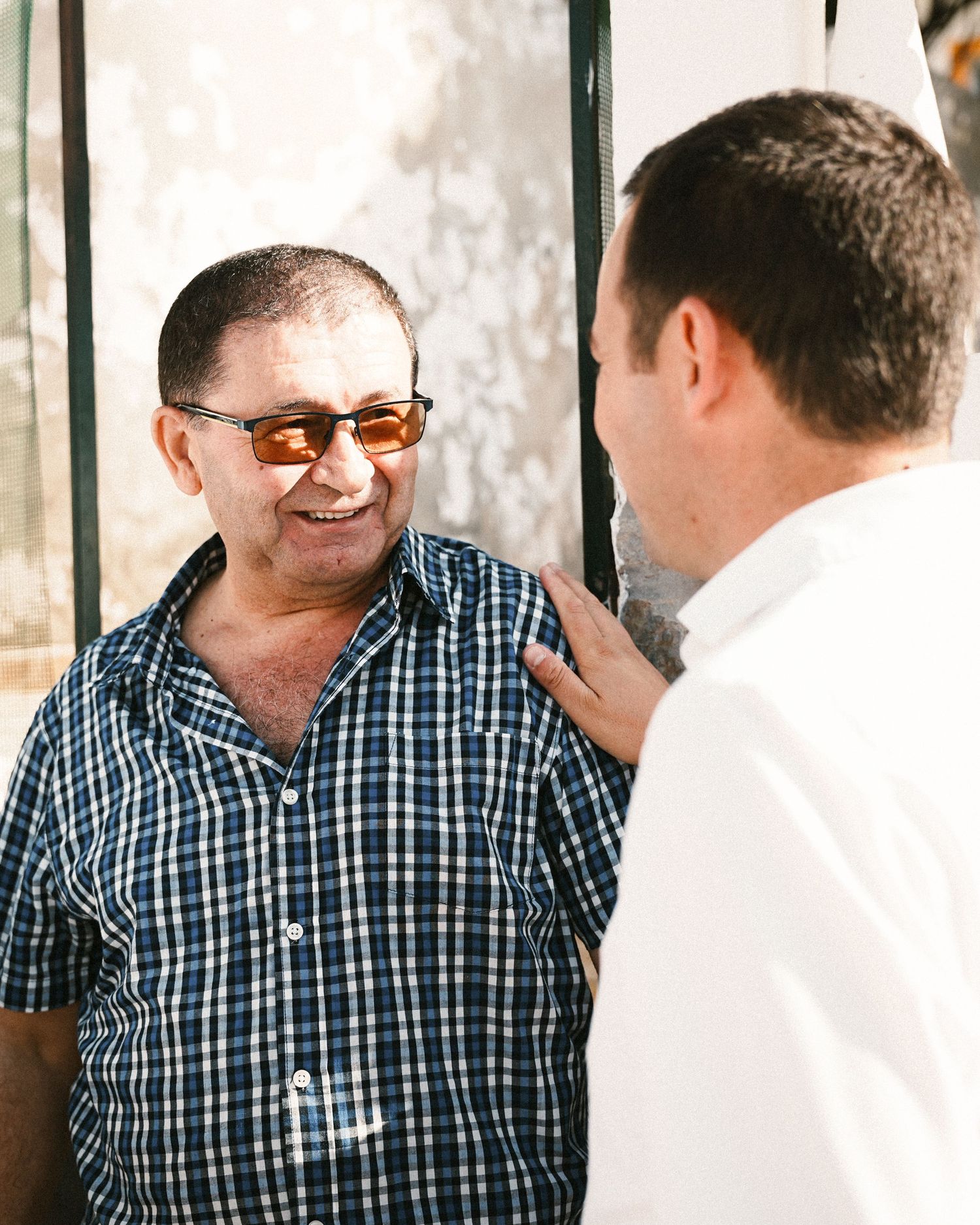 Two people in casual attire having an animated conversation outdoors.