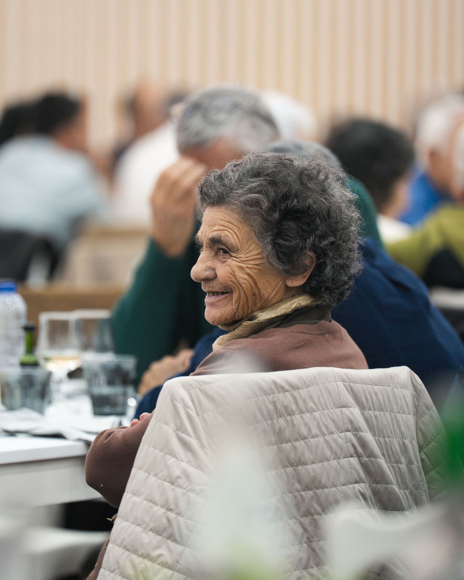 Side profile view of someone with gray hair seated at a social gathering.