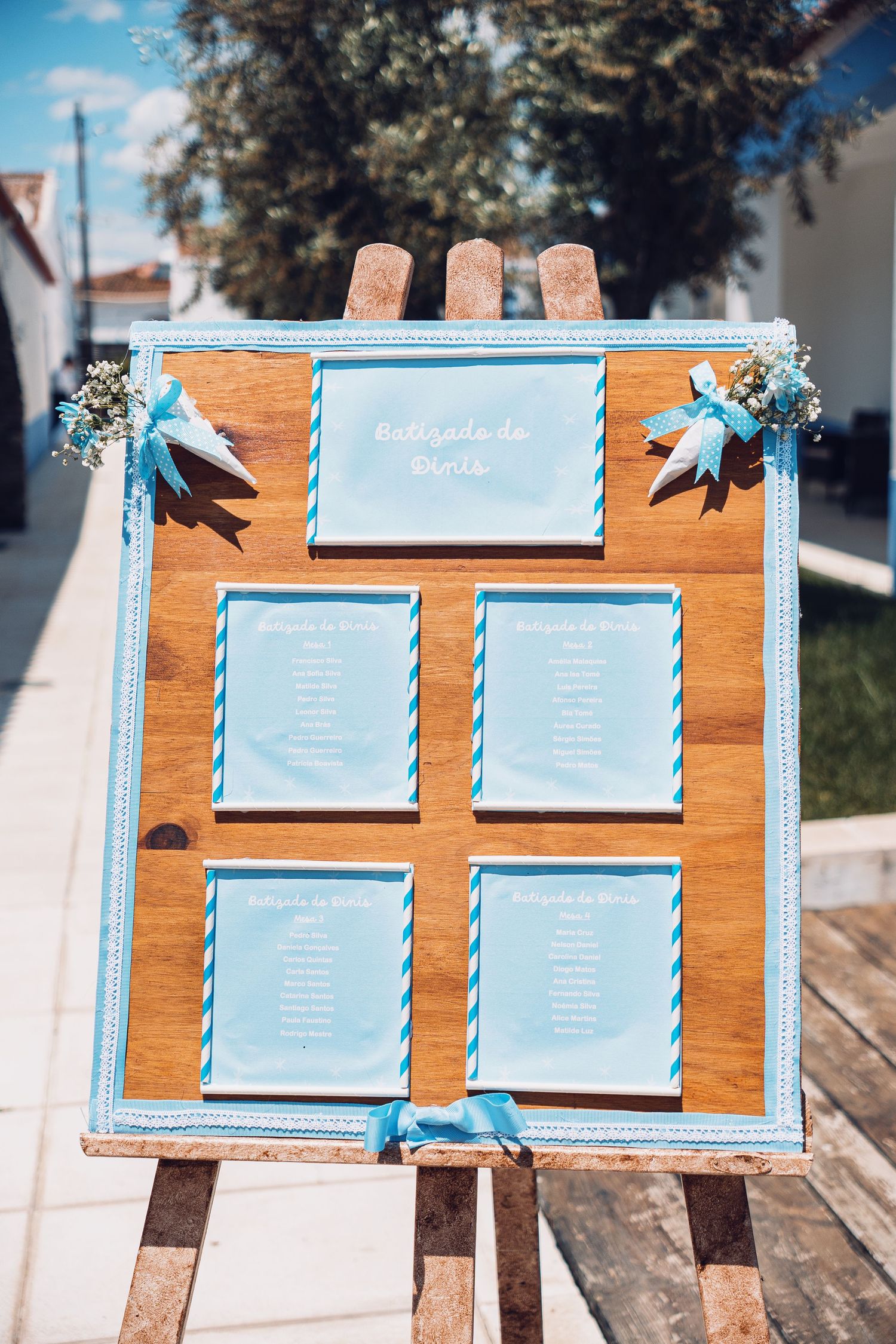 Light blue seating chart display on wooden boards for wedding reception.