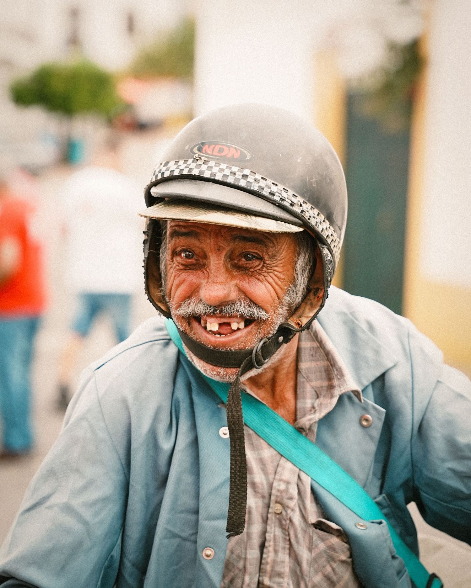 A close-up sequence of a motorcyclist wearing a checkered helmet and blue jacket.