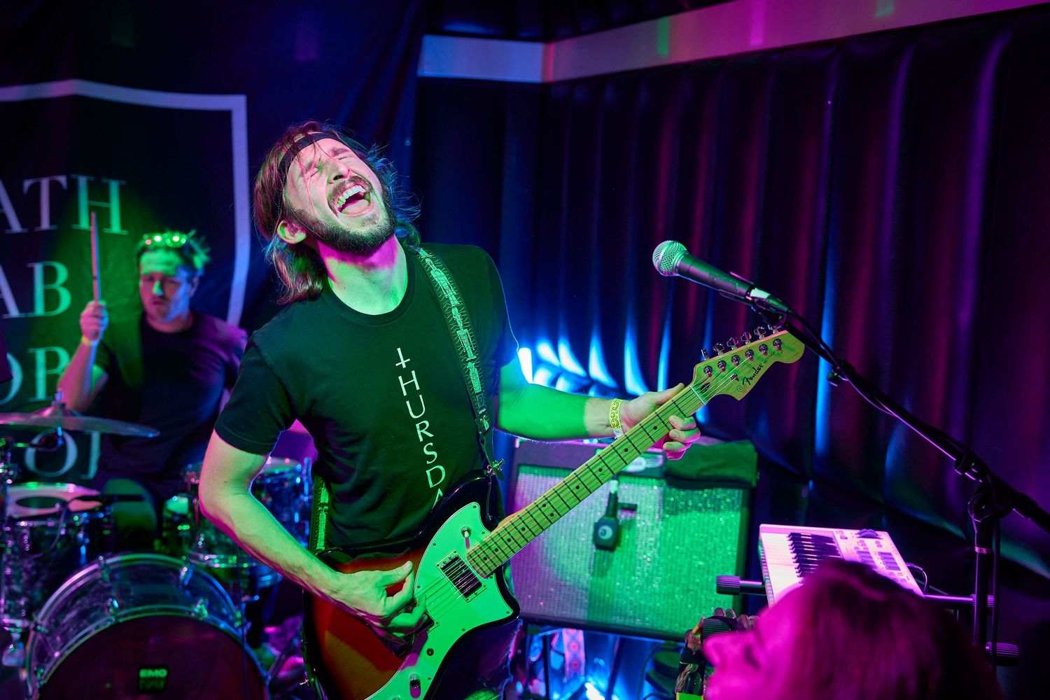 Guitarist playing on stage under colorful concert lighting