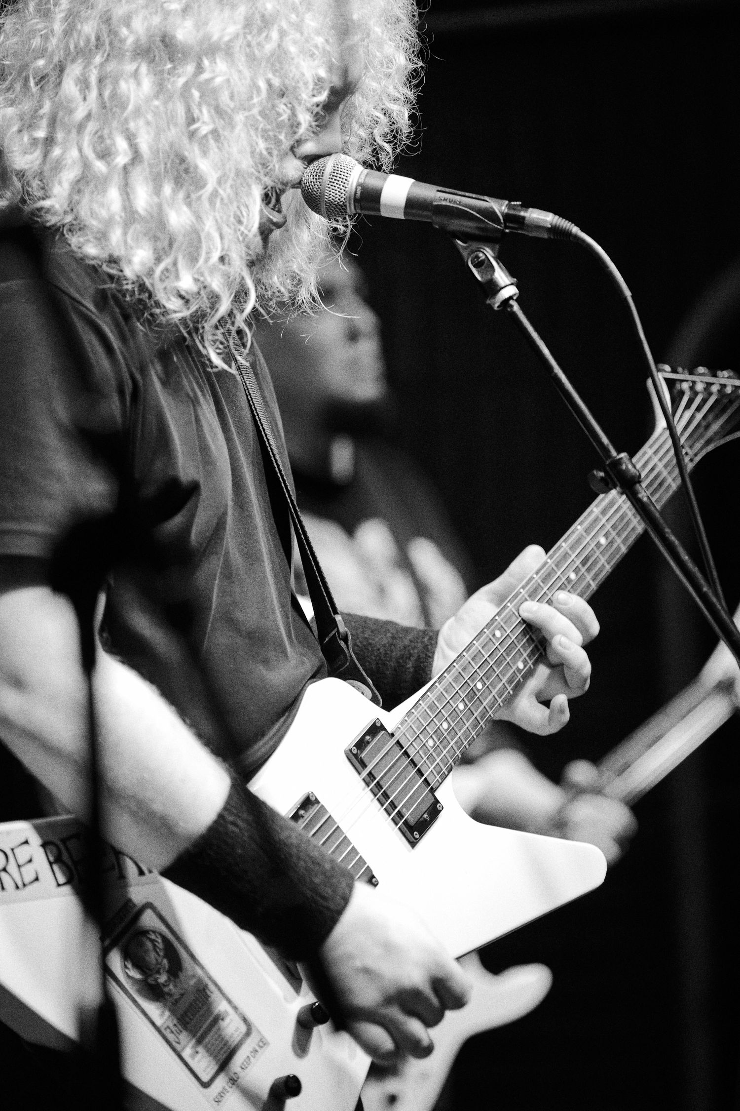 Black and white close-up of guitarist performing on stage