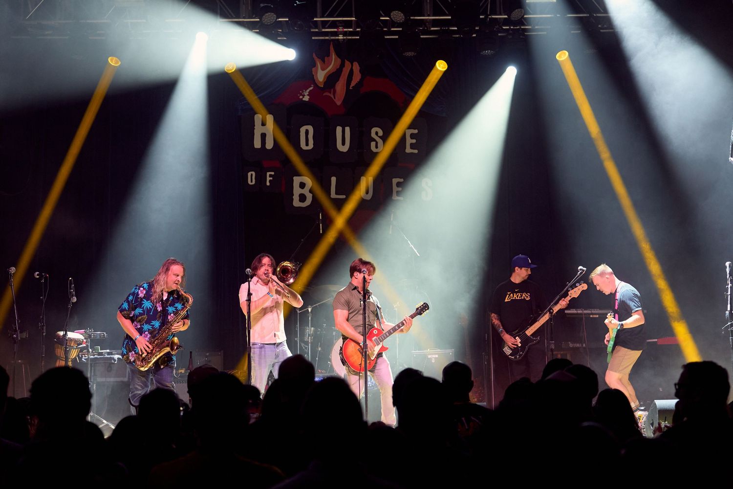 Wide shot of band performing on stage at a live concert with stage lighting