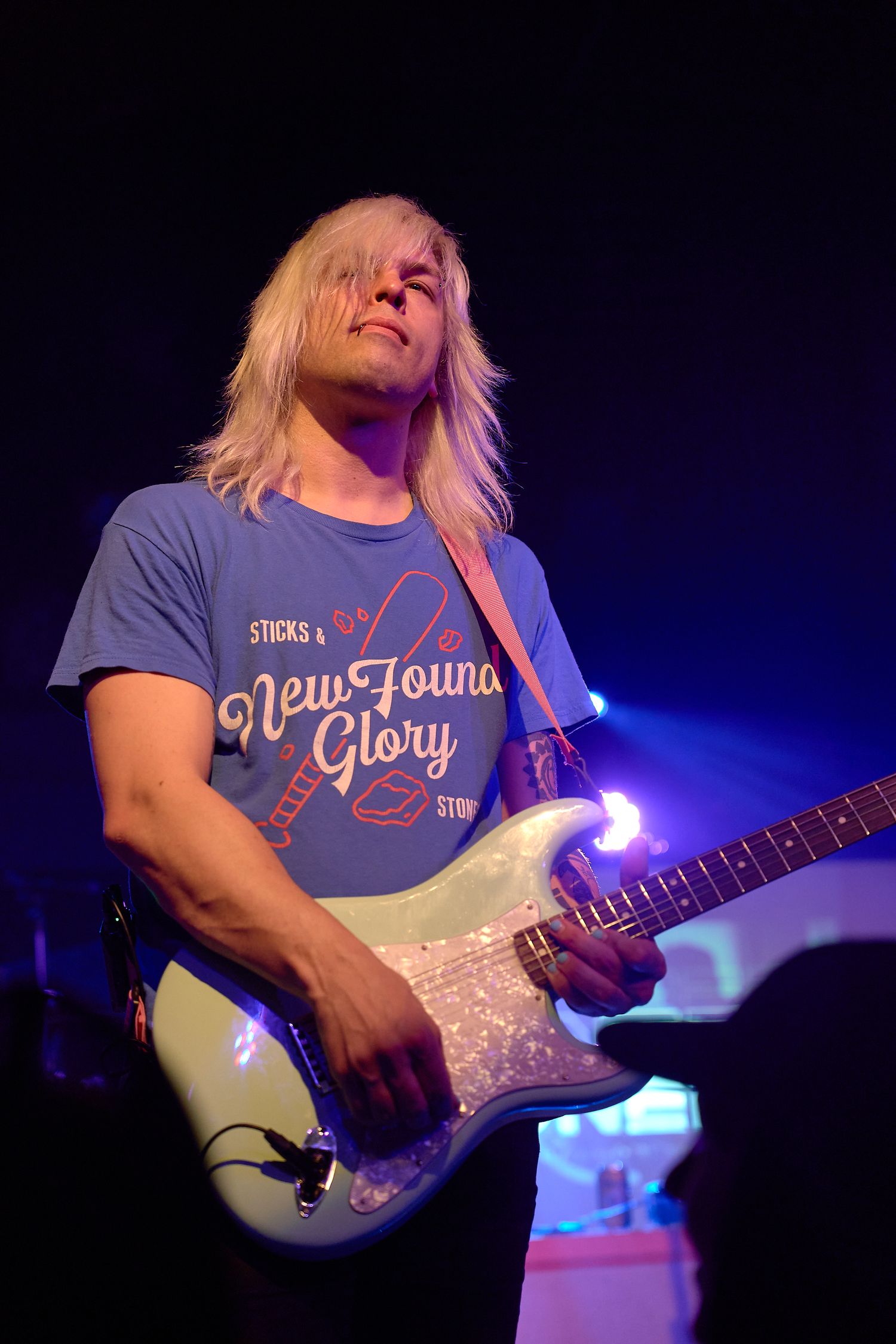 Guitarist performing solo under stage lights