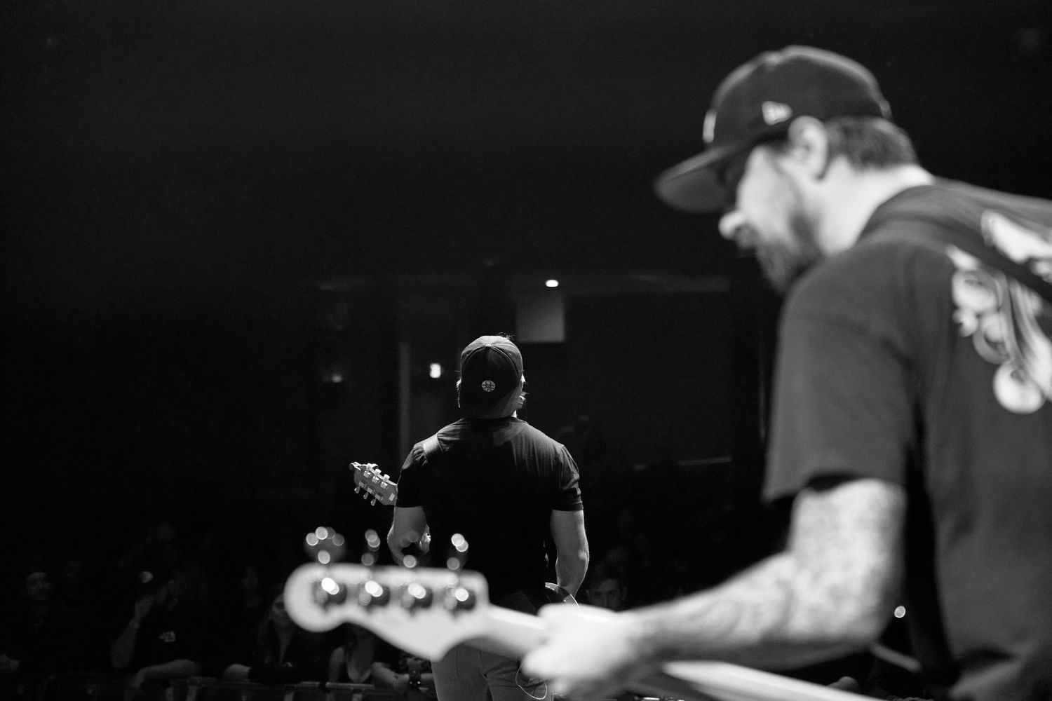 Black and white photo of bassist performing on stage during a live concert