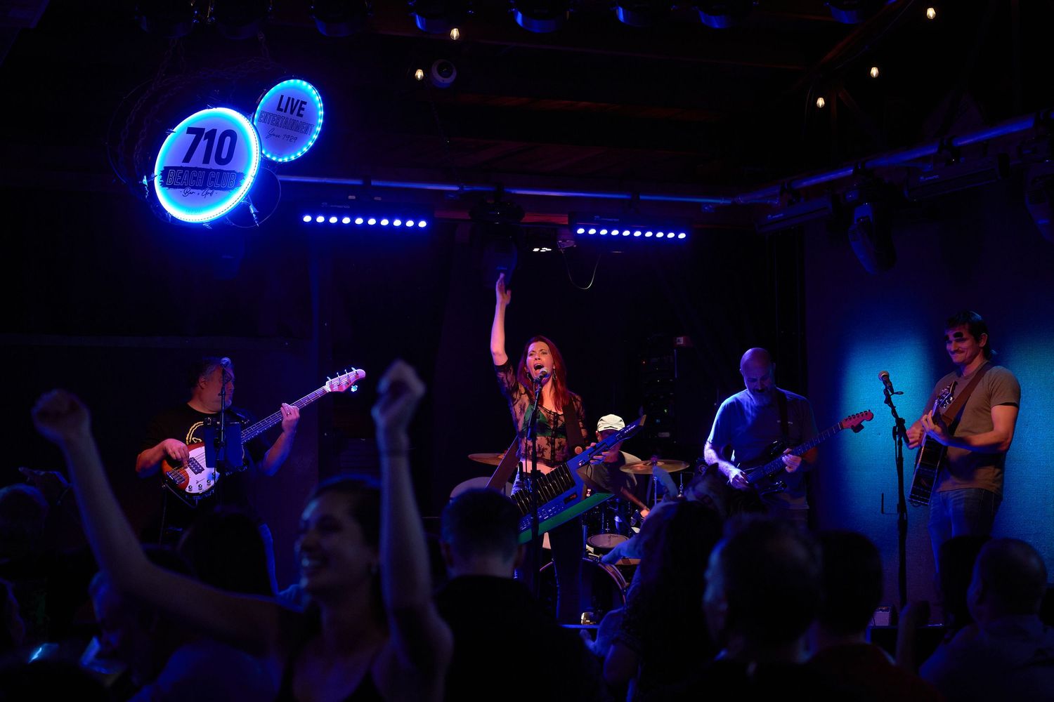 Band performing live on stage in a dark concert venue