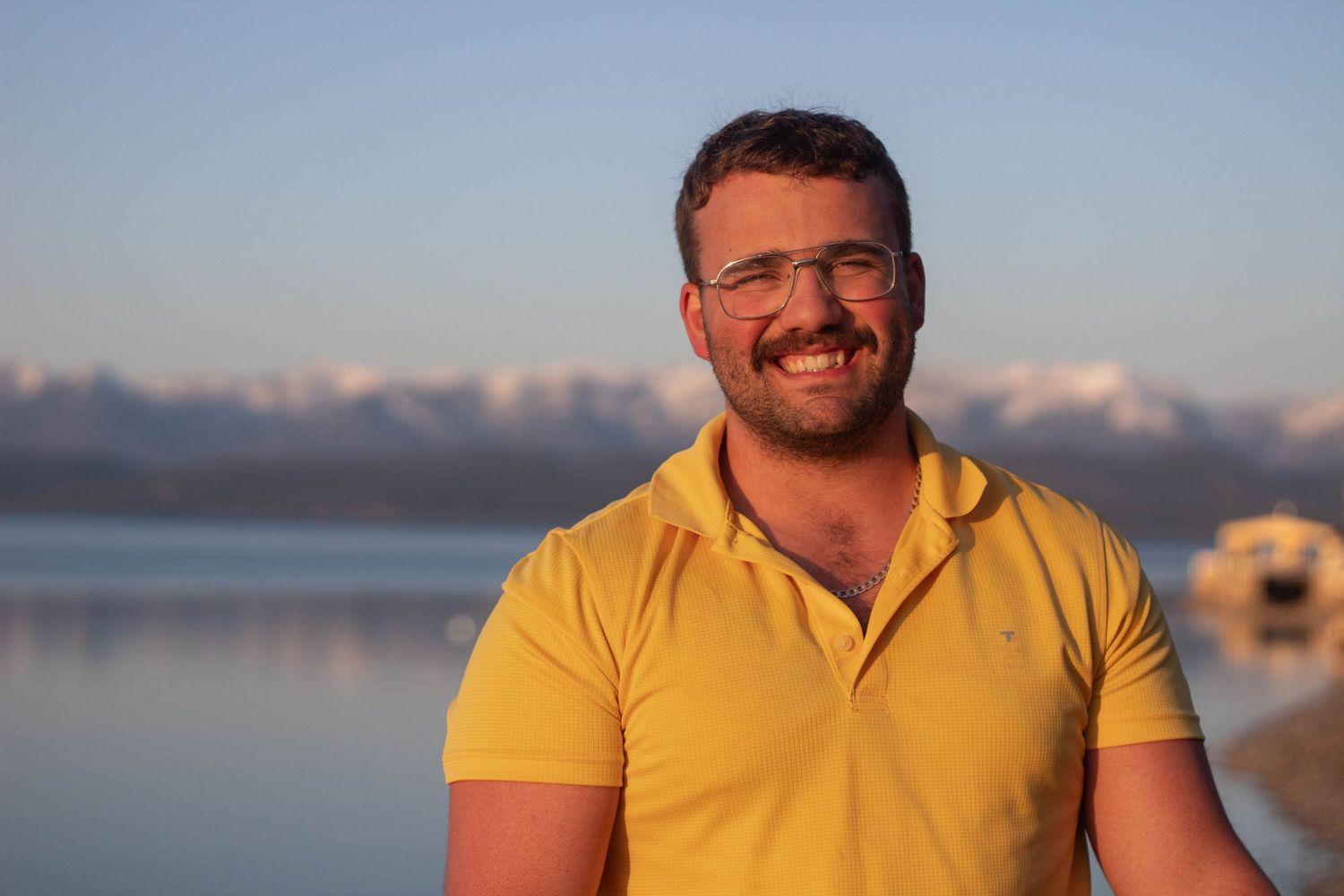 A person in a yellow shirt poses against a backdrop of scenic mountains and outdoor landscapes in multiple photos.