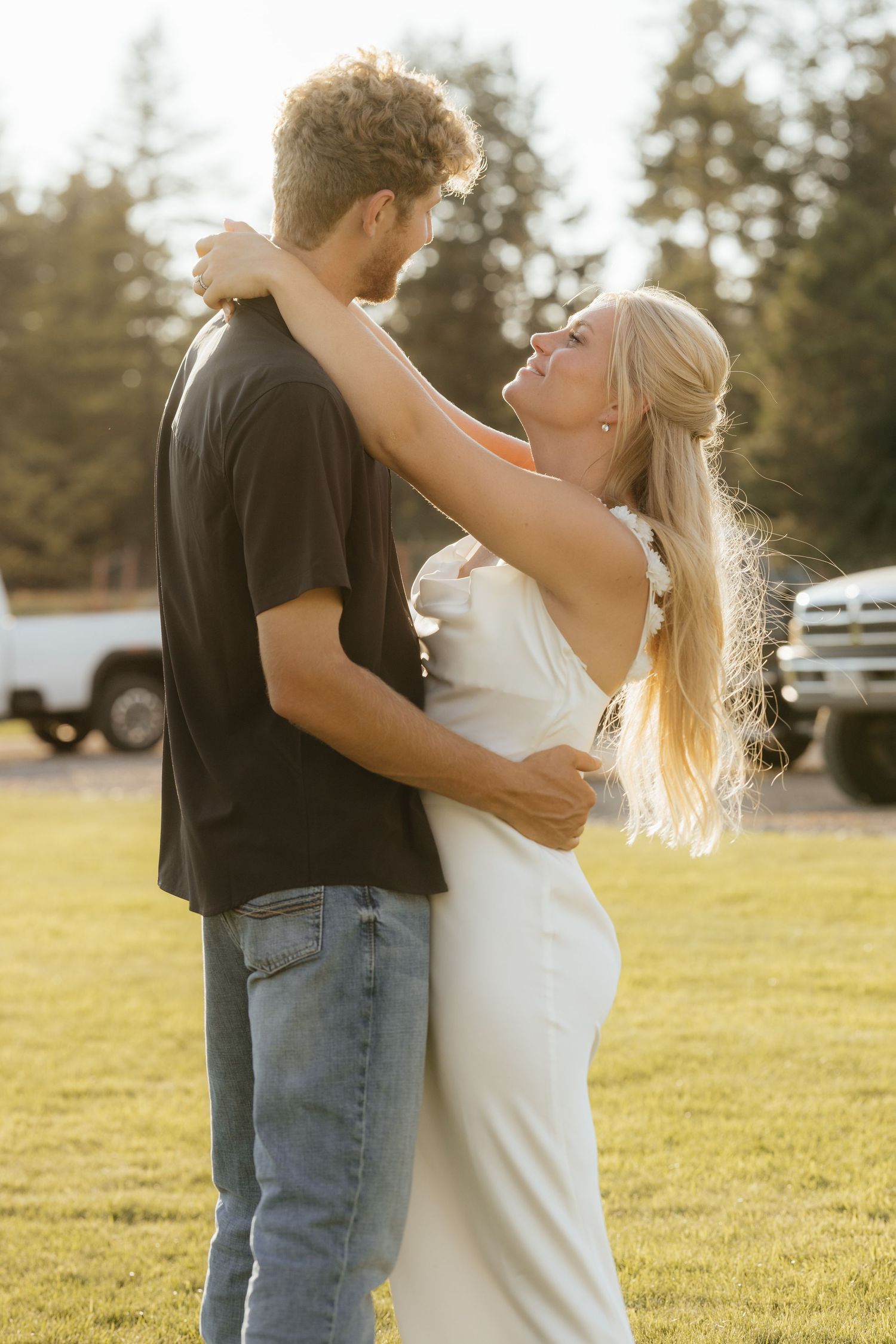 Romantic dance sequence in a sunlit field with couple in casual attire.