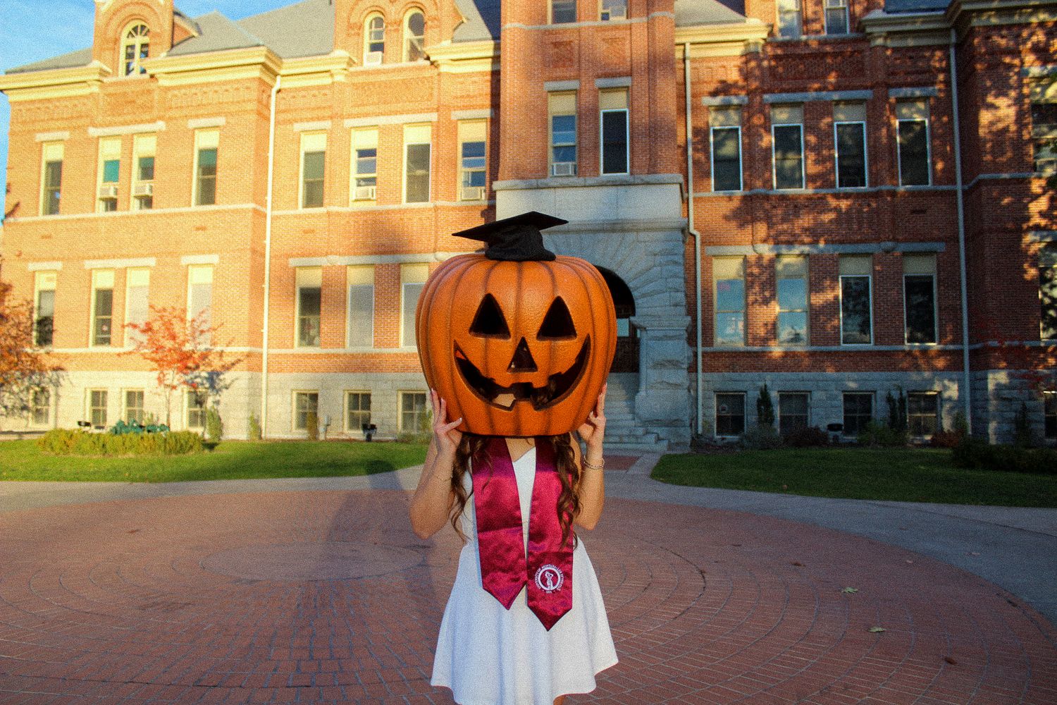 A whimsical Halloween photo series showing six images of a pumpkin head figure posing around a college campus.