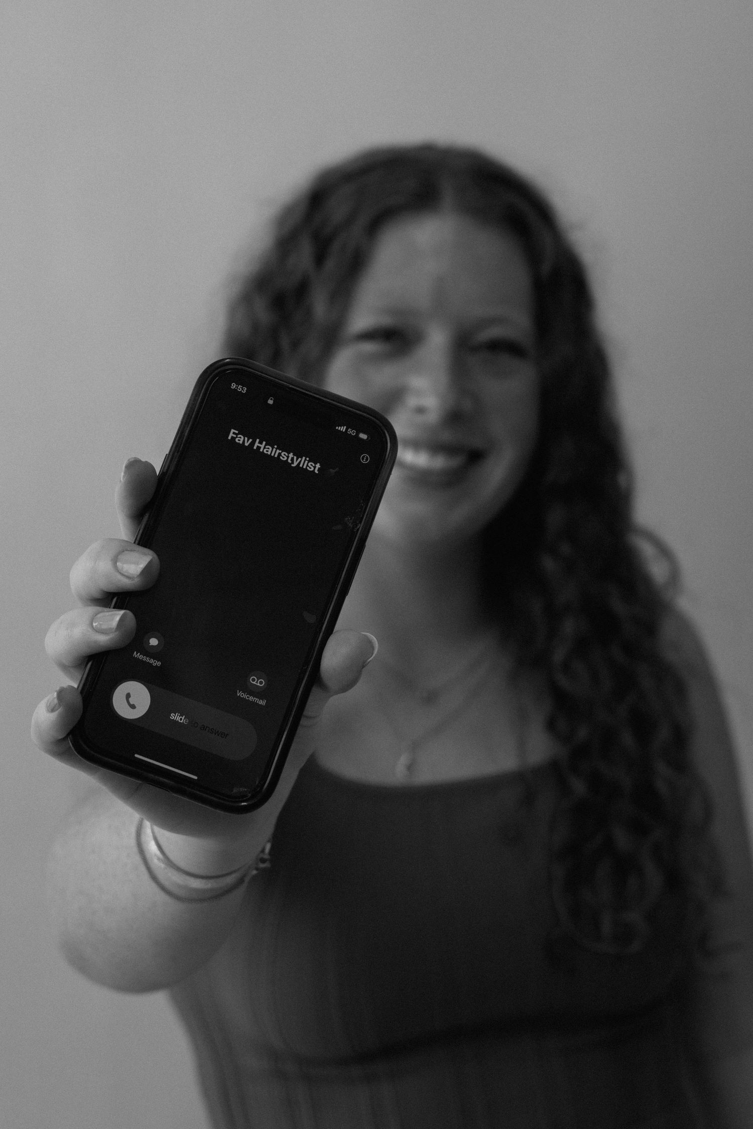 A series of black and white photos showing a person with curly hair holding and interacting with a smartwatch.