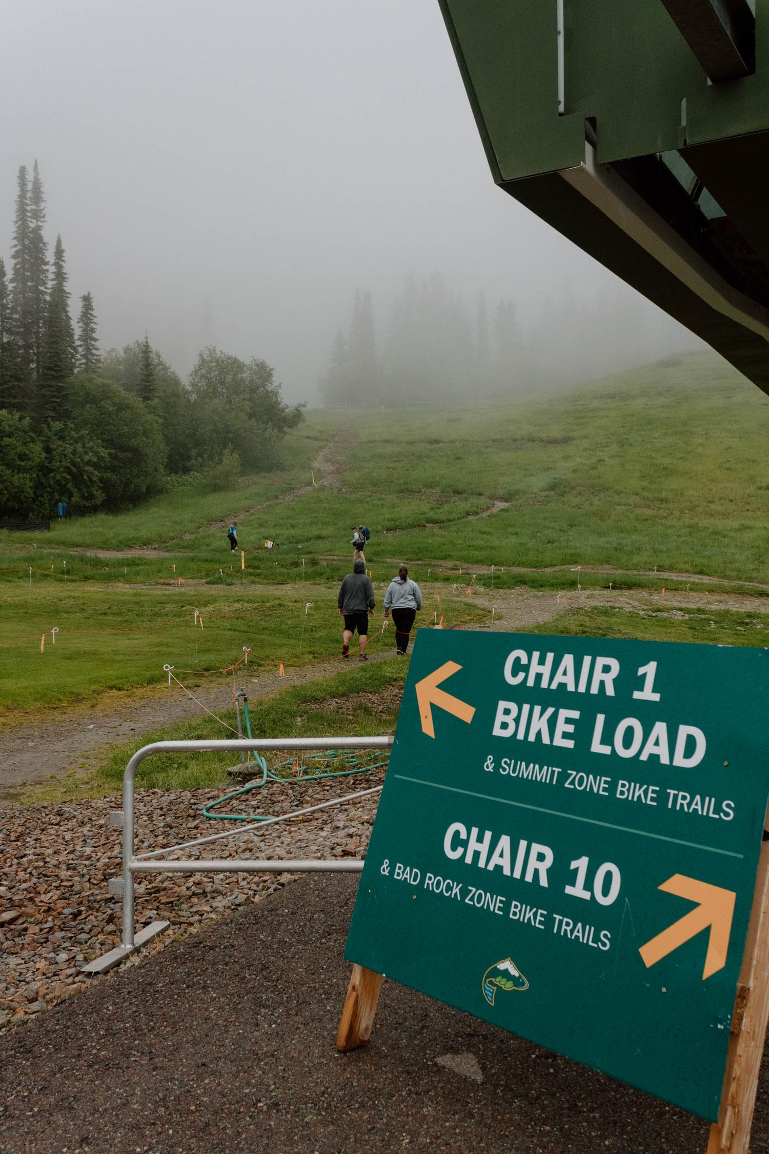 Foggy mountain trail signs directing to Chair 1 and Chair 10 ski lifts.