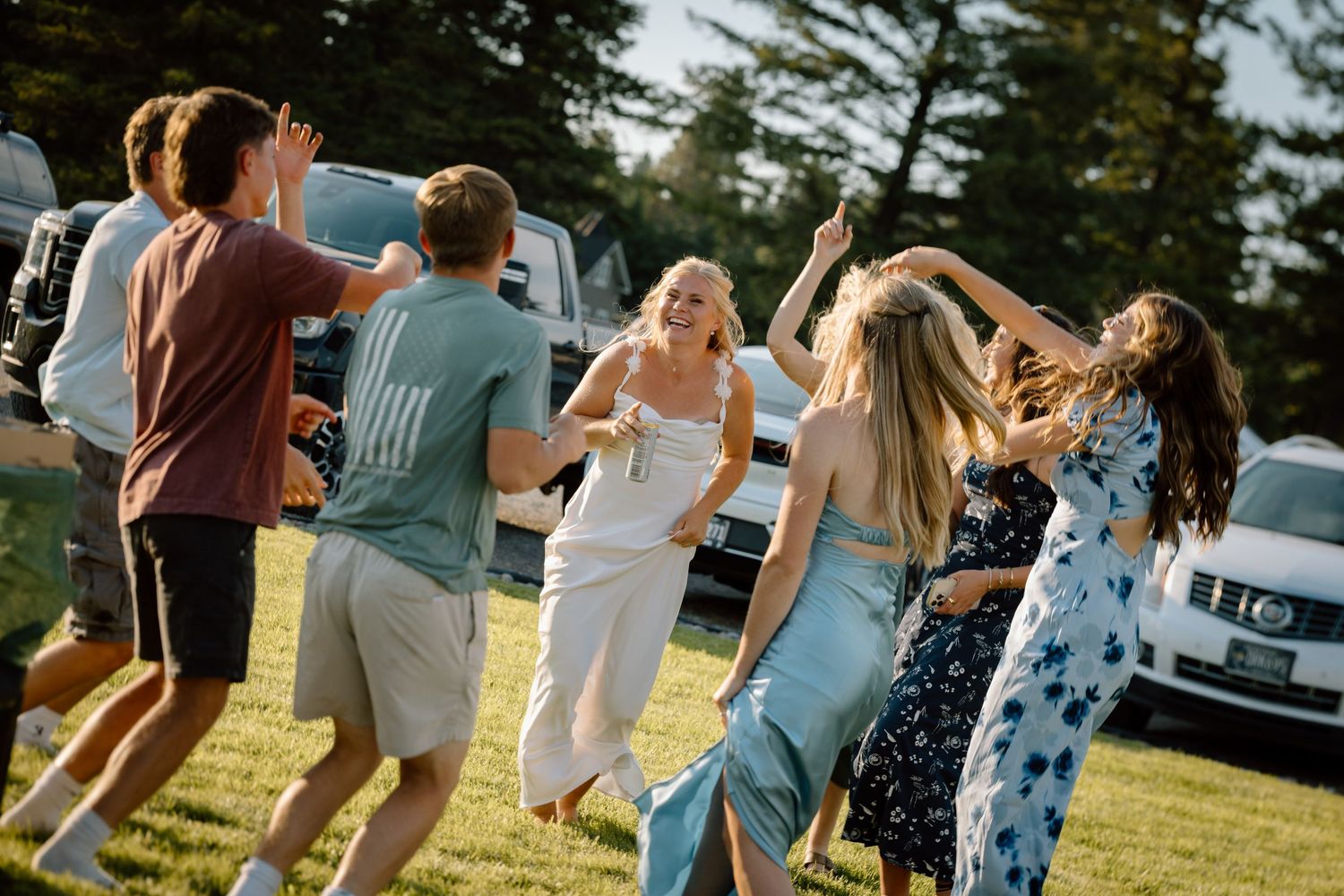 Group of people dancing together outdoors during a celebratory event.