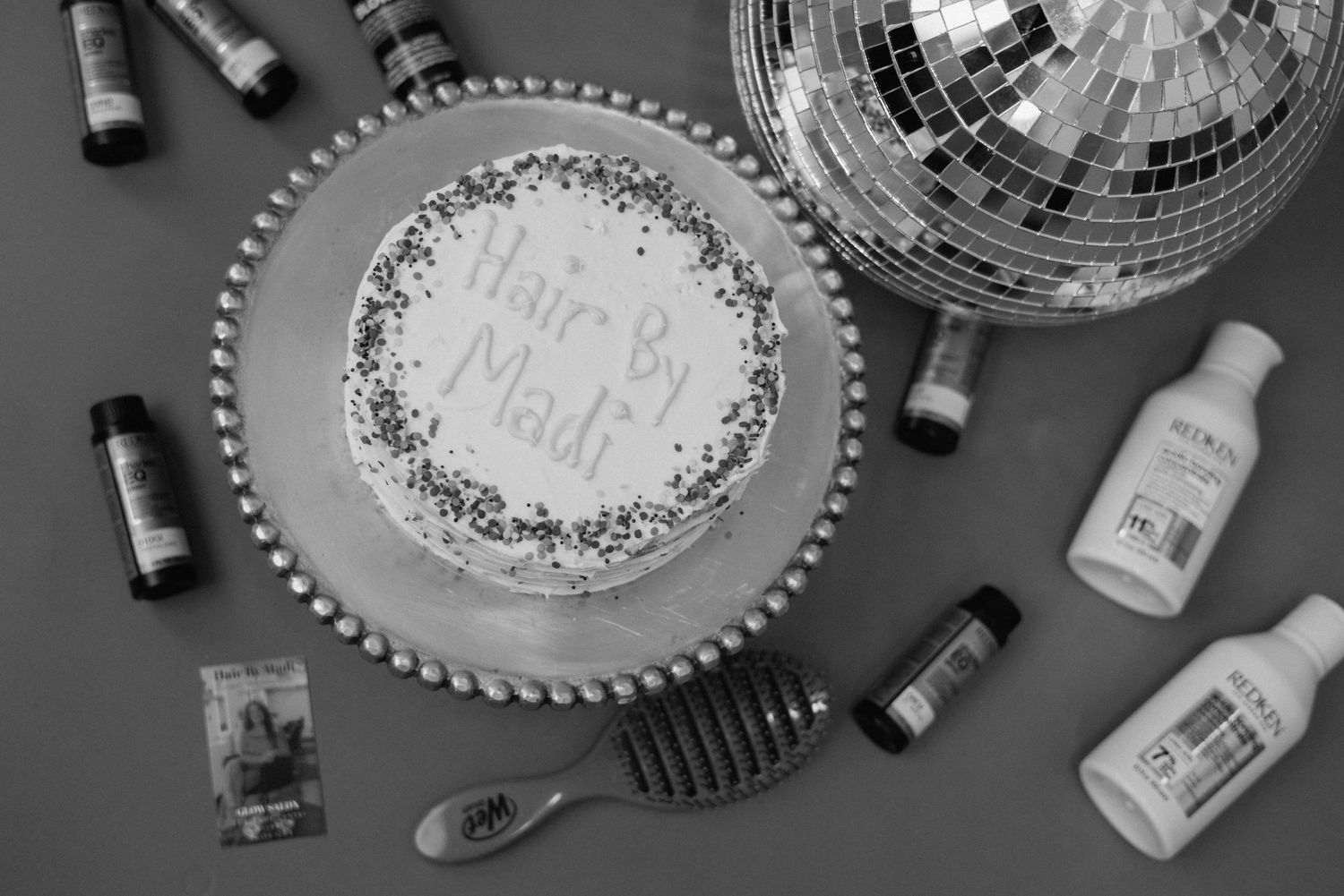 Flat lay arrangement of disco balls and bottles on a dark surface creating a party atmosphere.