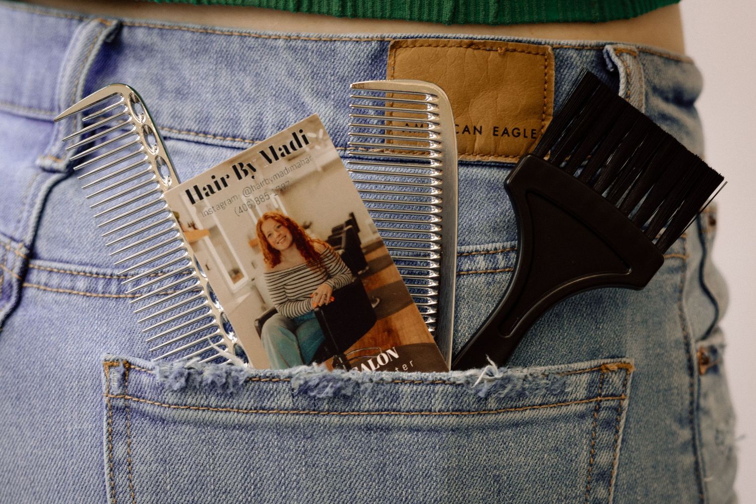 A credit card and bank statements peek out of a light blue denim jeans pocket.