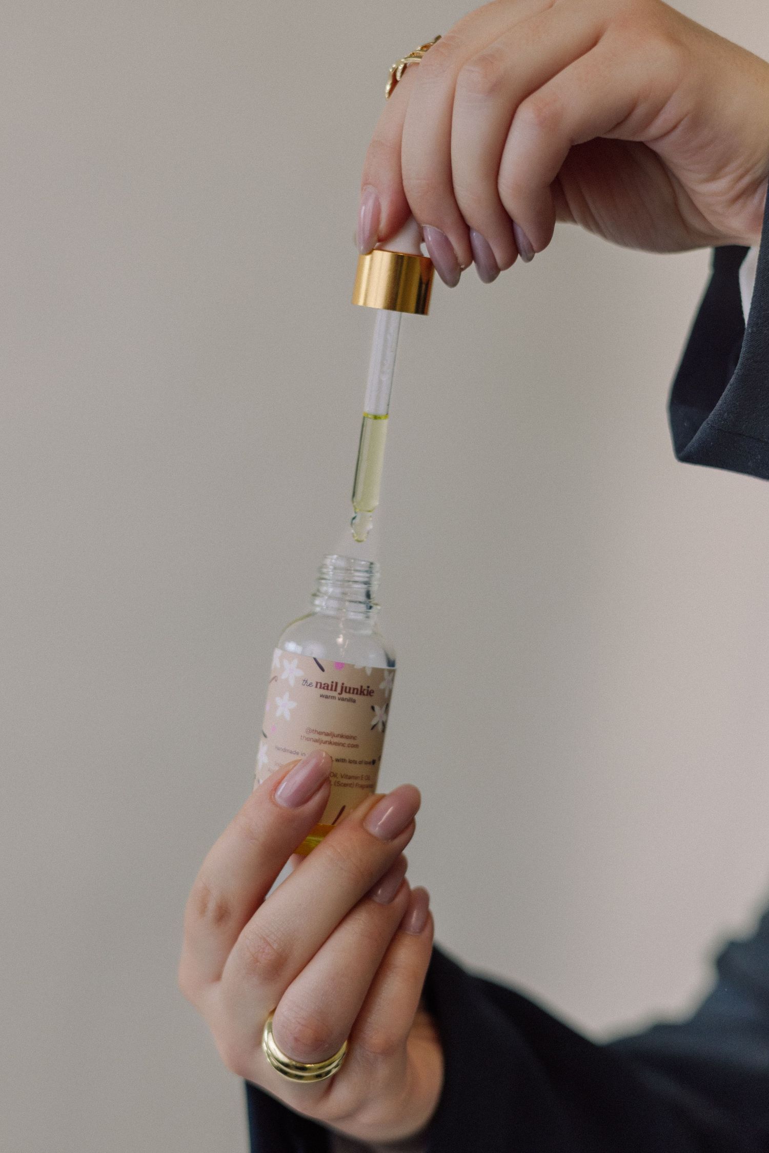 Hands demonstrating how to open and apply a glass perfume bottle with gold cap in multiple steps.
