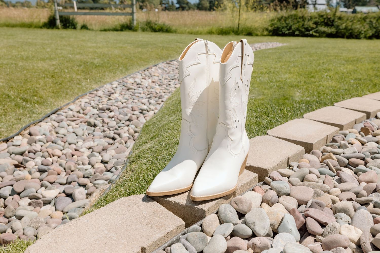 White bridal shoes displayed on decorative stone pathway.