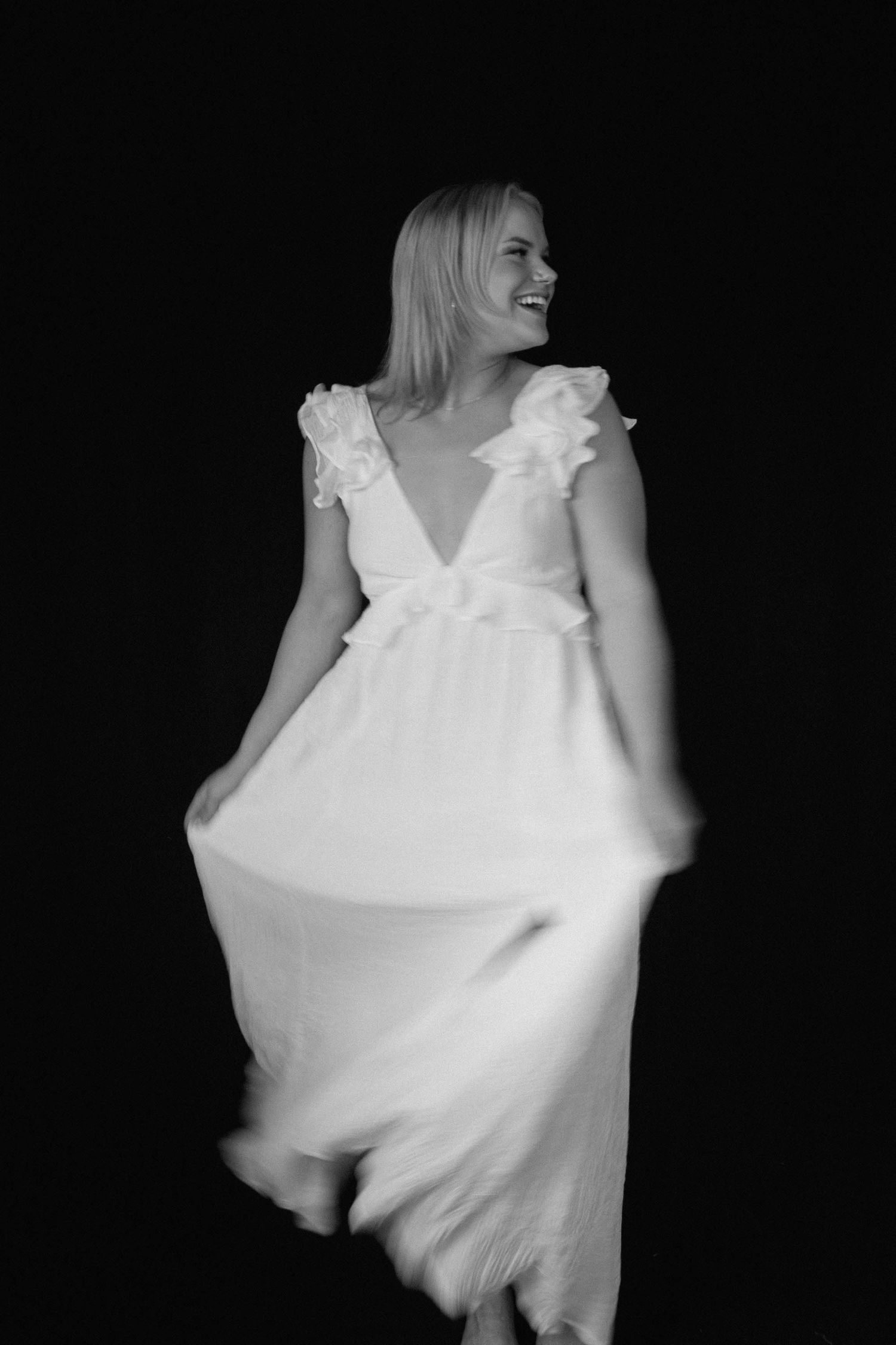 Artistic black and white portrait series showing flowing white fabric movement against dark background.