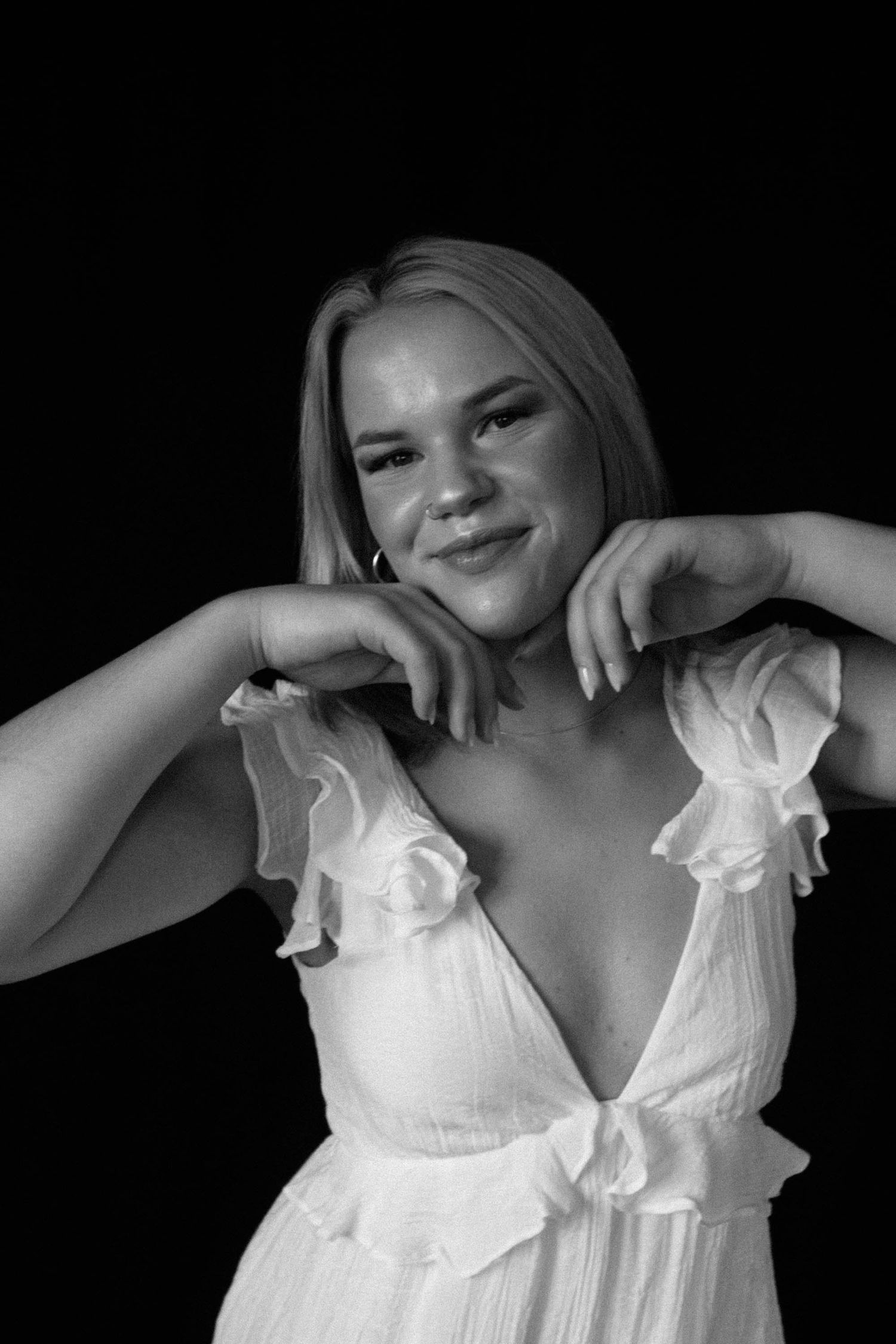 A series of black and white portraits showing someone wearing a white ruffled dress against a dark background.