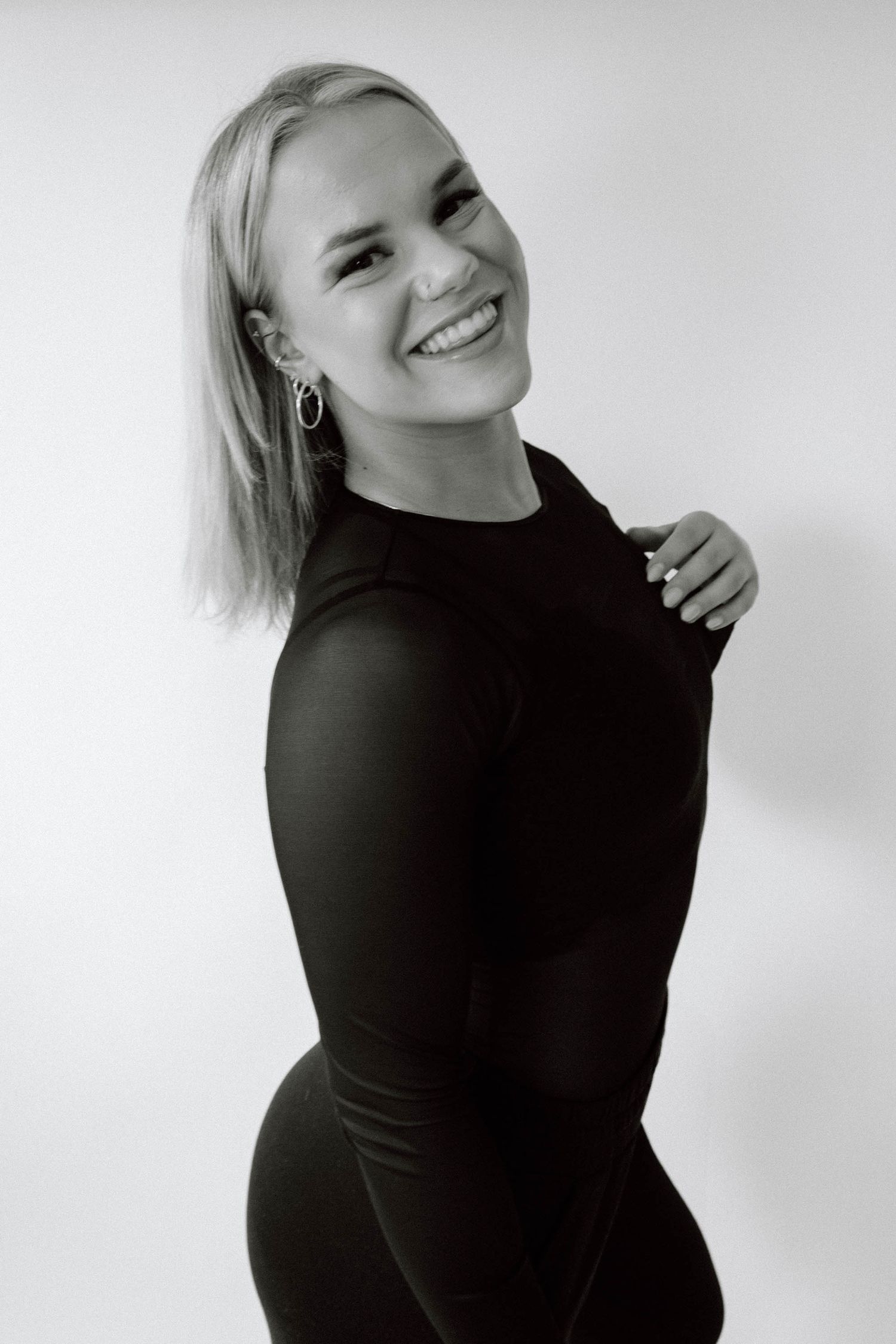 Black and white portrait series showing joyful expressions and natural poses against a light background.