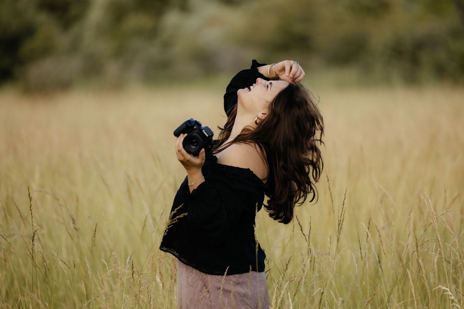 Photographer in black taking creative shots in a golden field.