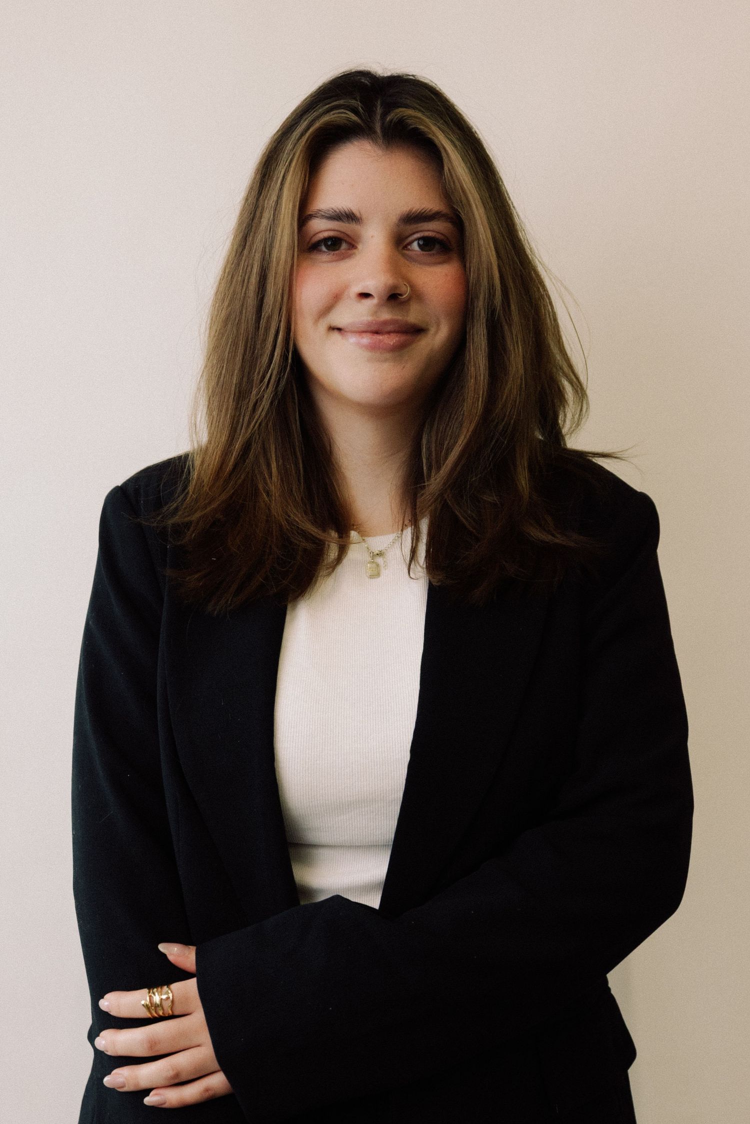 Professional portrait series showing someone in a black blazer and white top against a neutral background.