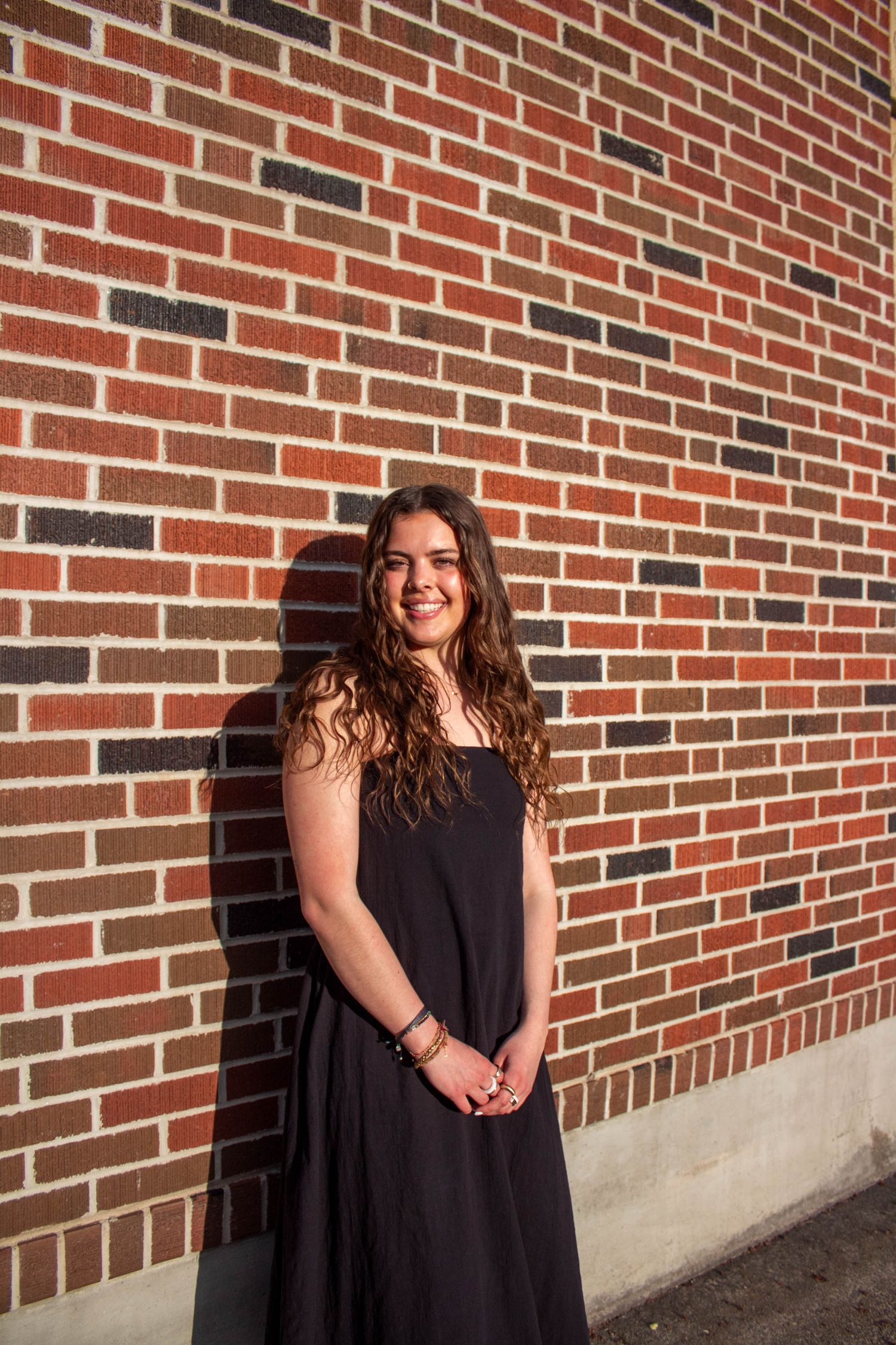 A series of candid photos against a red brick building wall.