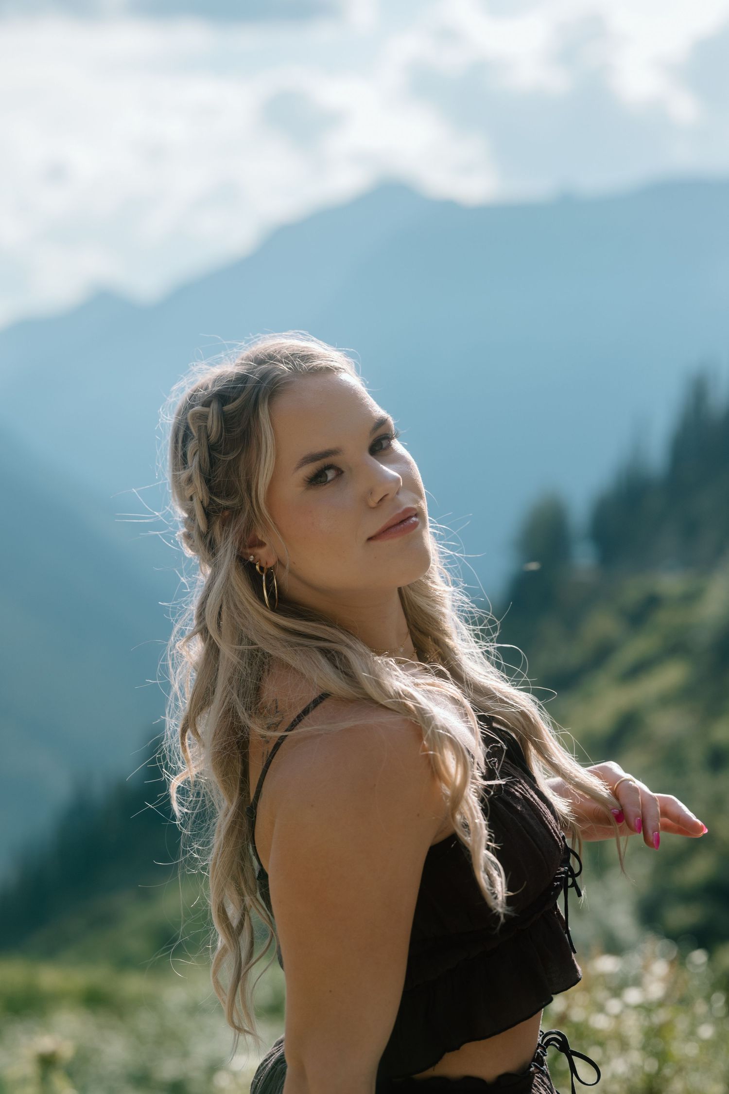 Sunlight filters through clouds over mountain peaks during a summer photo session.