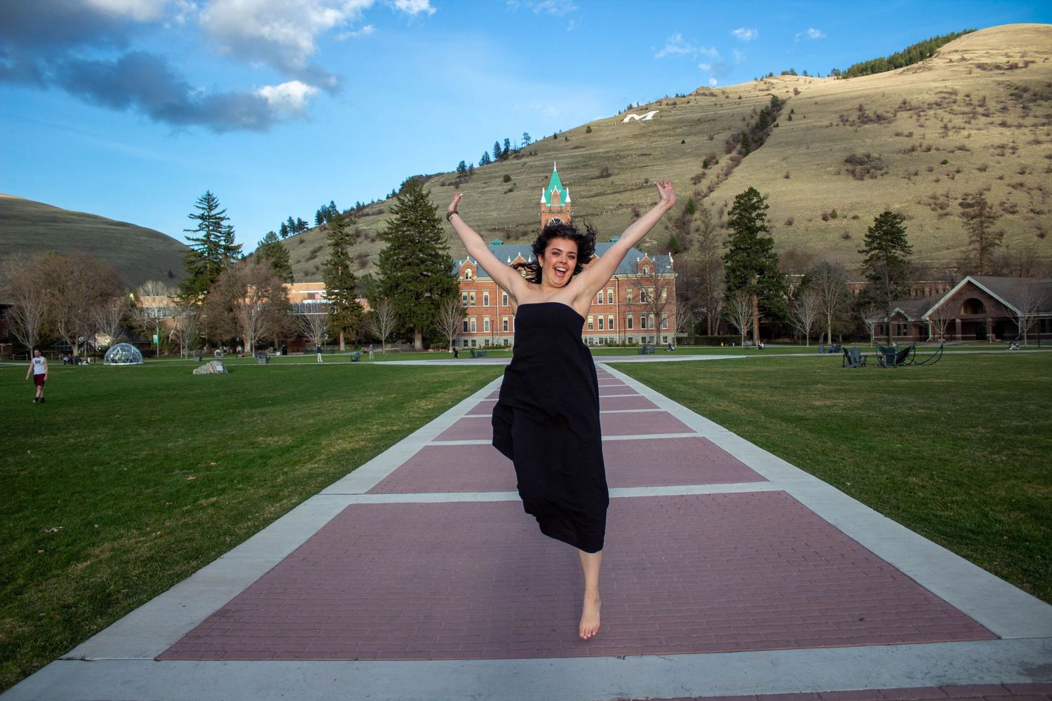 Series of dance poses on red pathway with mountain landscape backdrop.