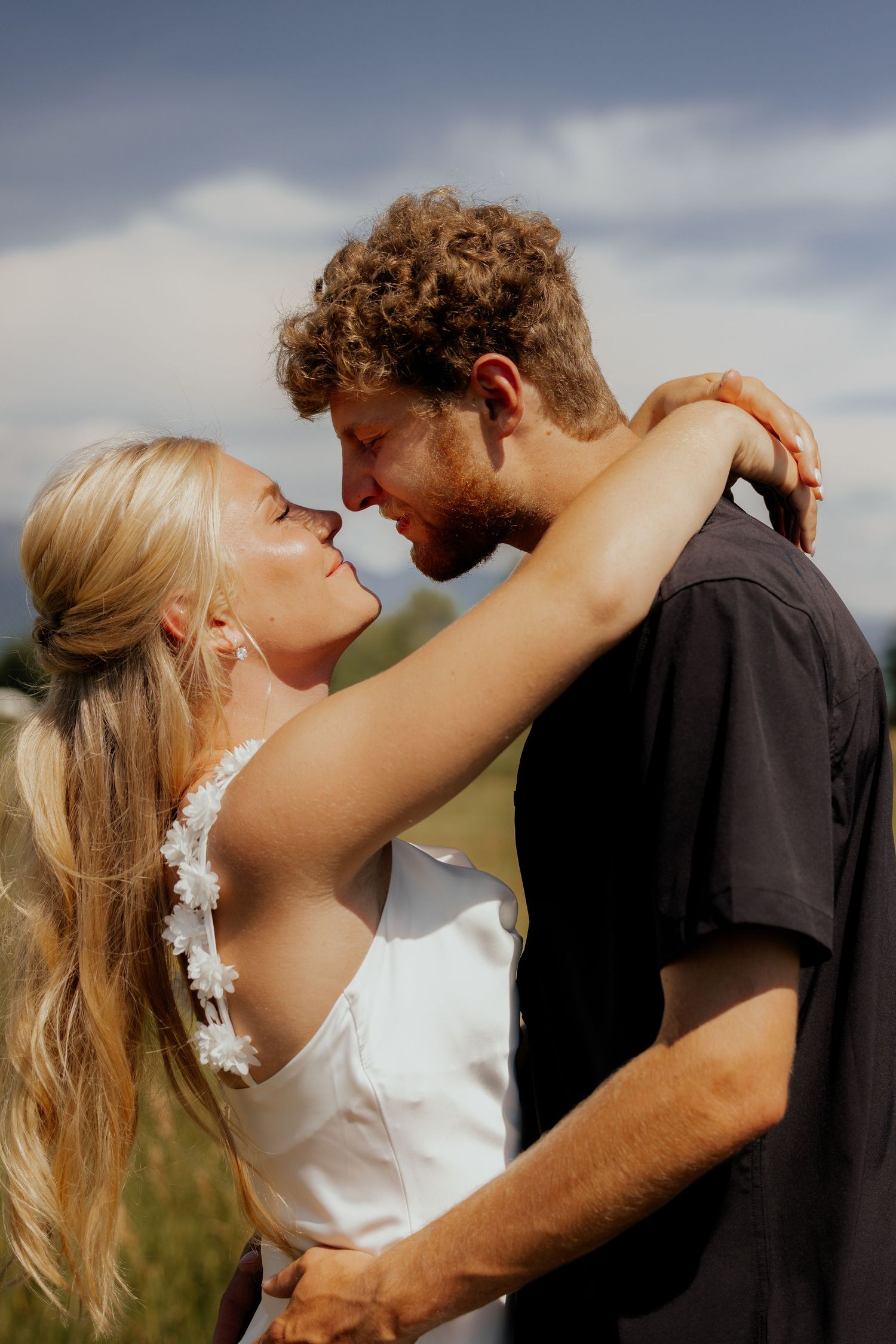 A romantic sequence of wedding photos shows a couple embracing in an outdoor setting against a moody sky.