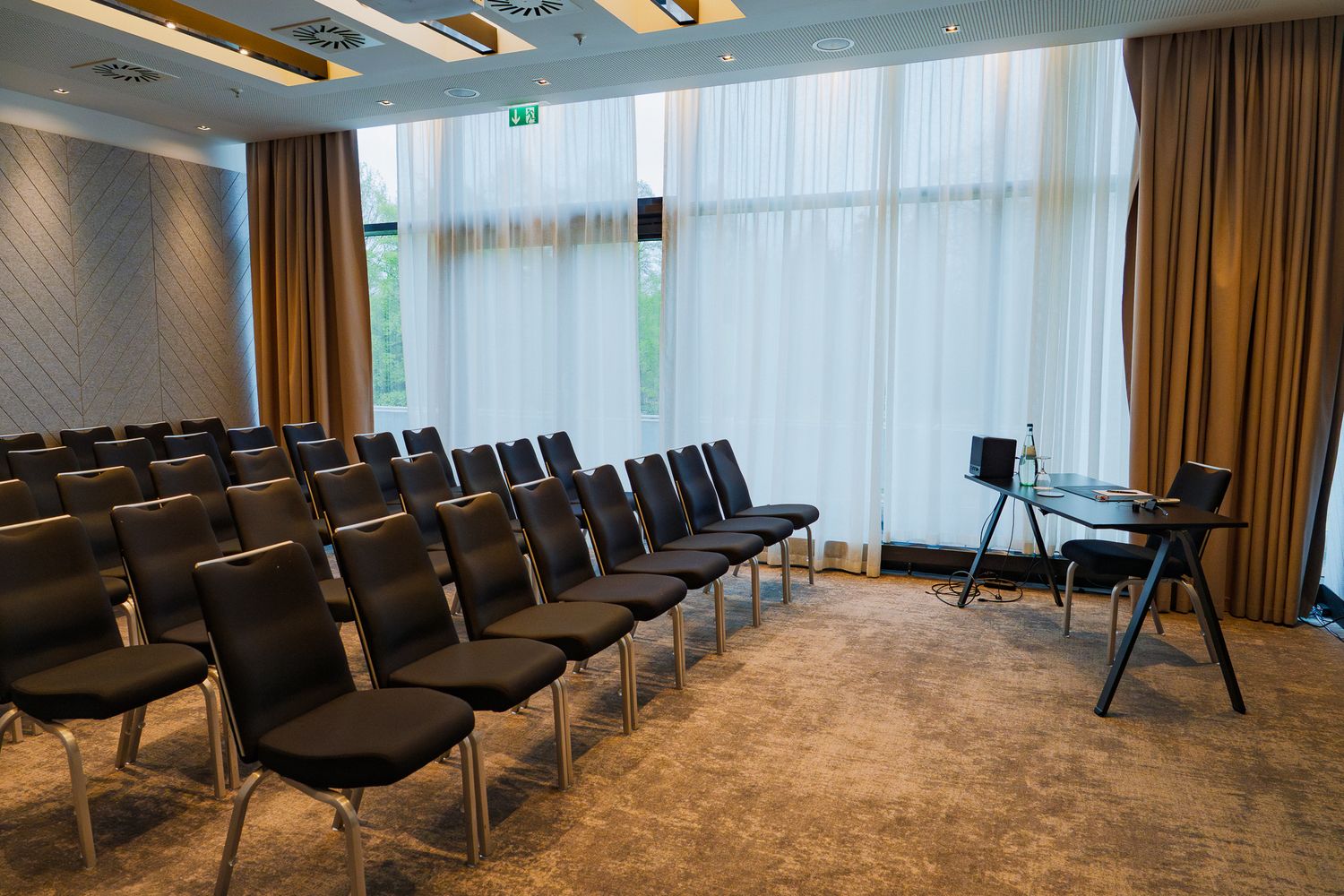 Bestuhlter Konferenzraum für die ColorCloud-Workshops mit Reihen aus schwarzen Stühlen und einem kleinen Tisch für den Redner