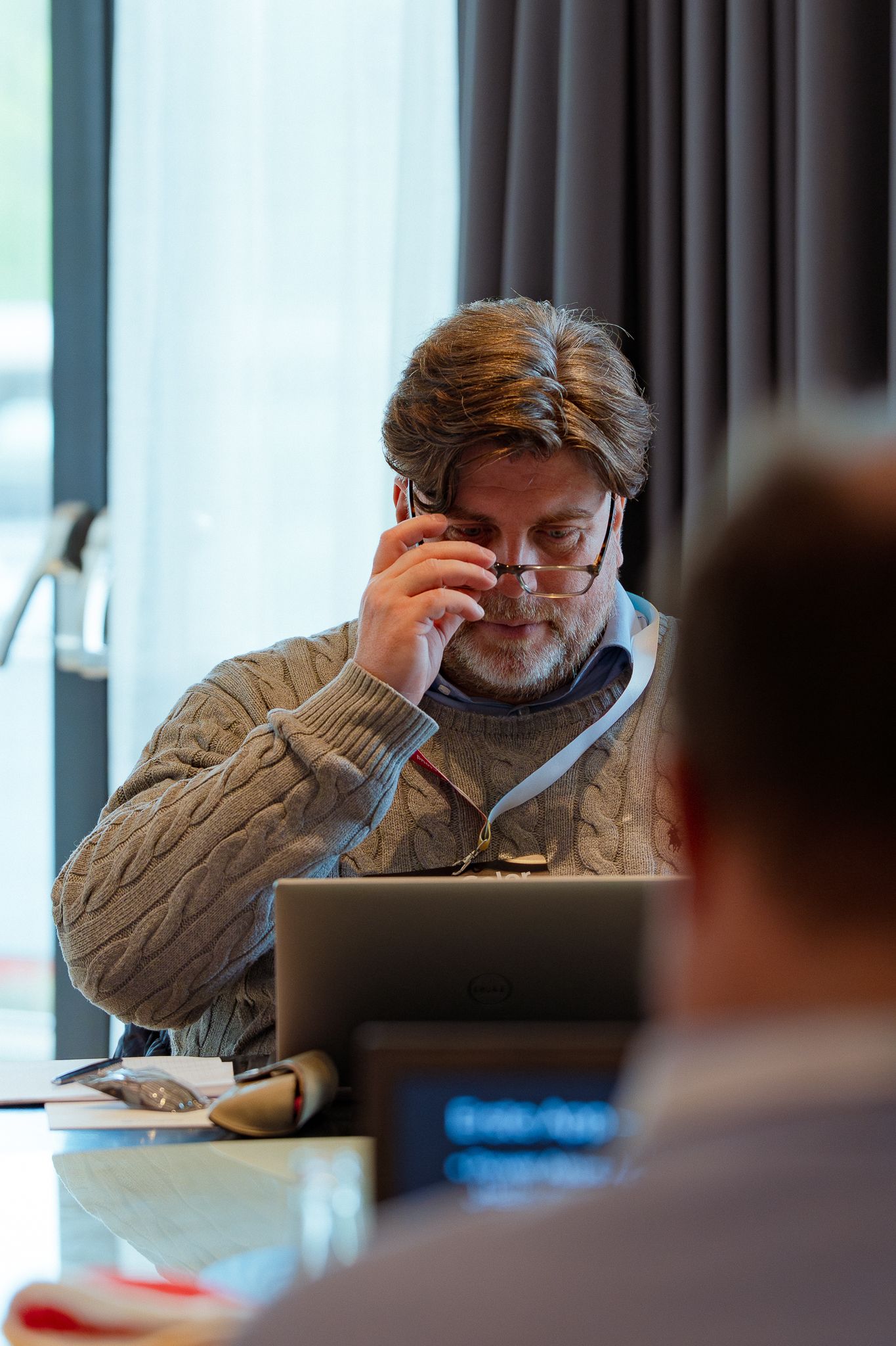 Ein Teilnehmer des ColorCloud Workshops rückt seine Brille zurecht und schaut auf seinen Laptop