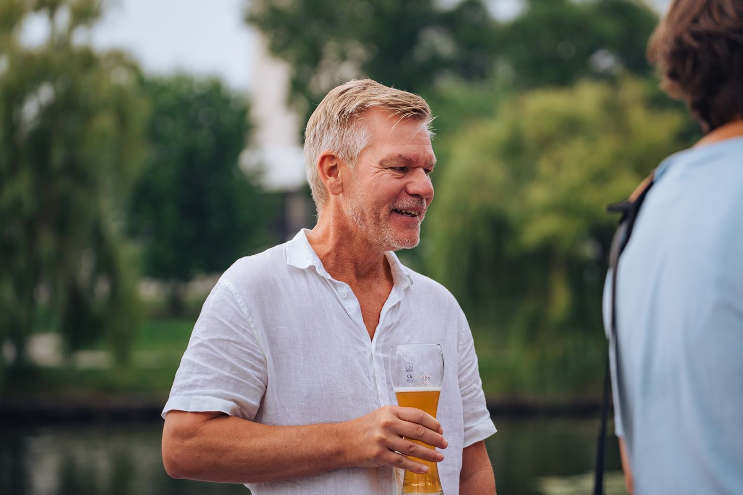 Lächelnder Mann mittleren Alters mit Bier in der Hand