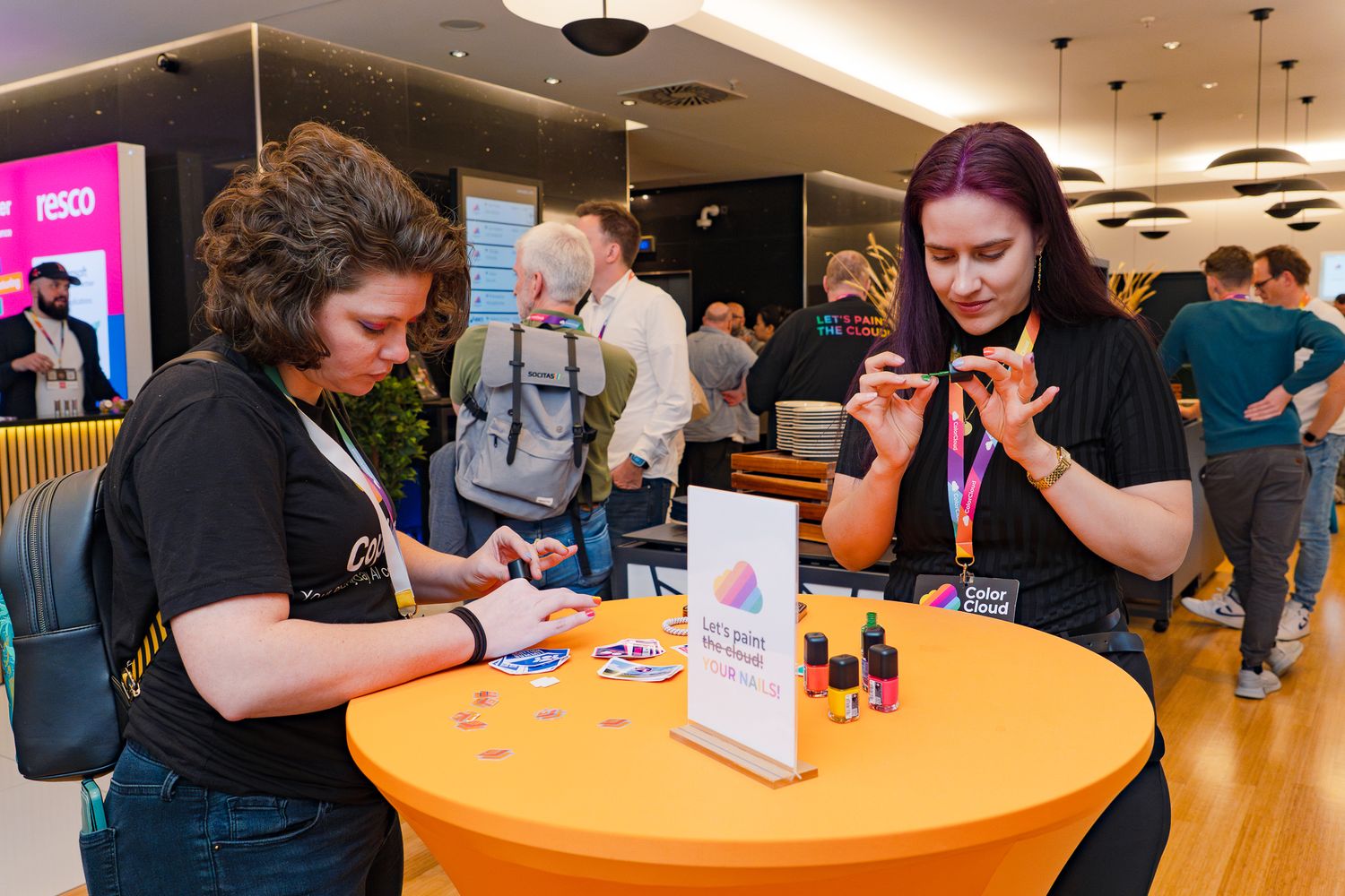 Cathrine Bruvold lackiert sich mit einer anderen Teilnehmerin an der ColorCloud 2025 im Foyer an einem Stehtisch die Fingernägel