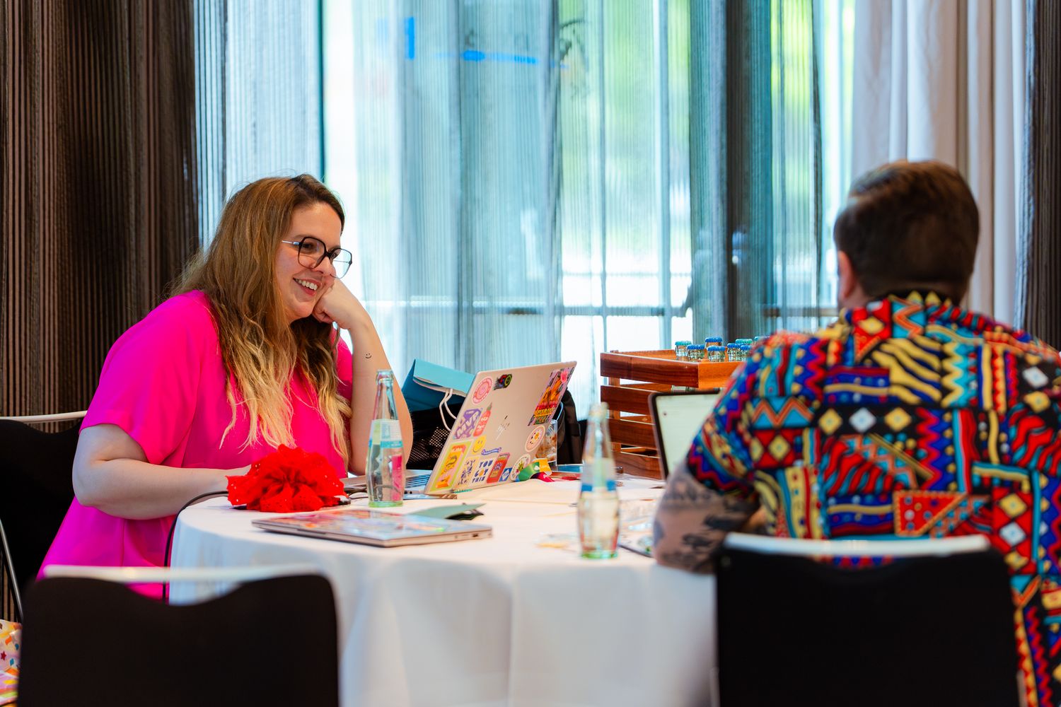Ana Inés Urrutia de Souza und William Dorrington unterhalten sich am Tisch auf dem ColorCloud PromptAthon