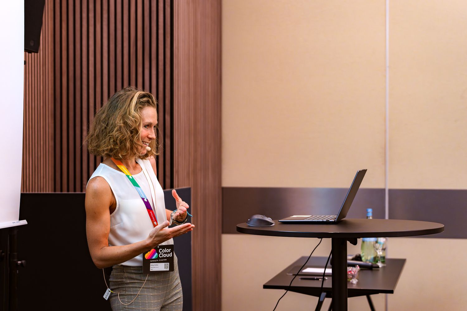 Amey Holden steht vor einem Laptop und hält vor den Teilnehmenden der ColorCloud-Konferenz einen Vortrag