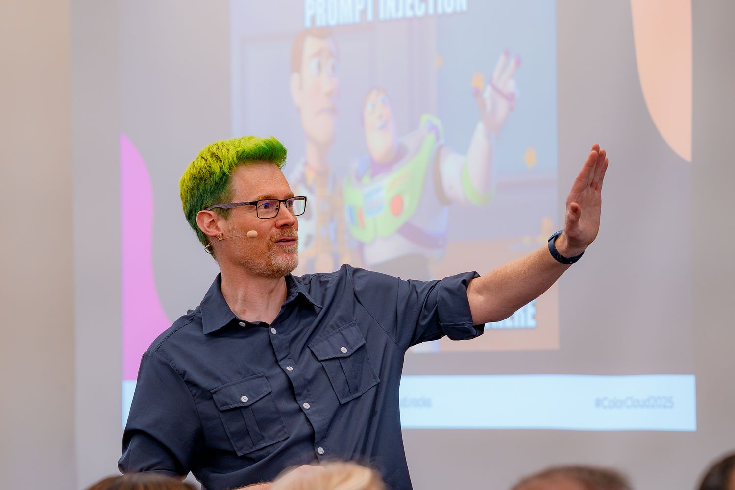 Scott Durow deutet während der Closing Note auf der ColorCloud nach rechts, die Leinwand hinter ihm zeigt ein Toy-Story-Meme