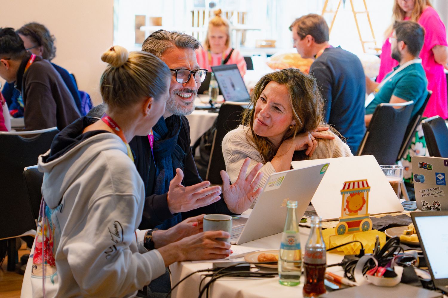 Drei Teilnehmende am ColorCloud-PromptAthon 2025 diskutieren vor einem Laptop