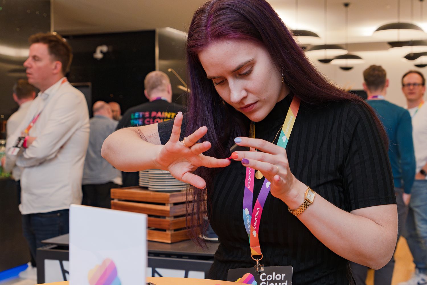 Cathrine Bruvold lackiert sich im Foyer der ColorCloud 2025 an einem Stehtisch die Fingernägel