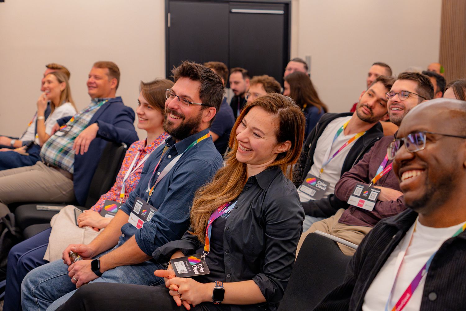 Lachende Teilnehmende, die sich die Keynote der ColorCloud Konferenz 2025 anhören