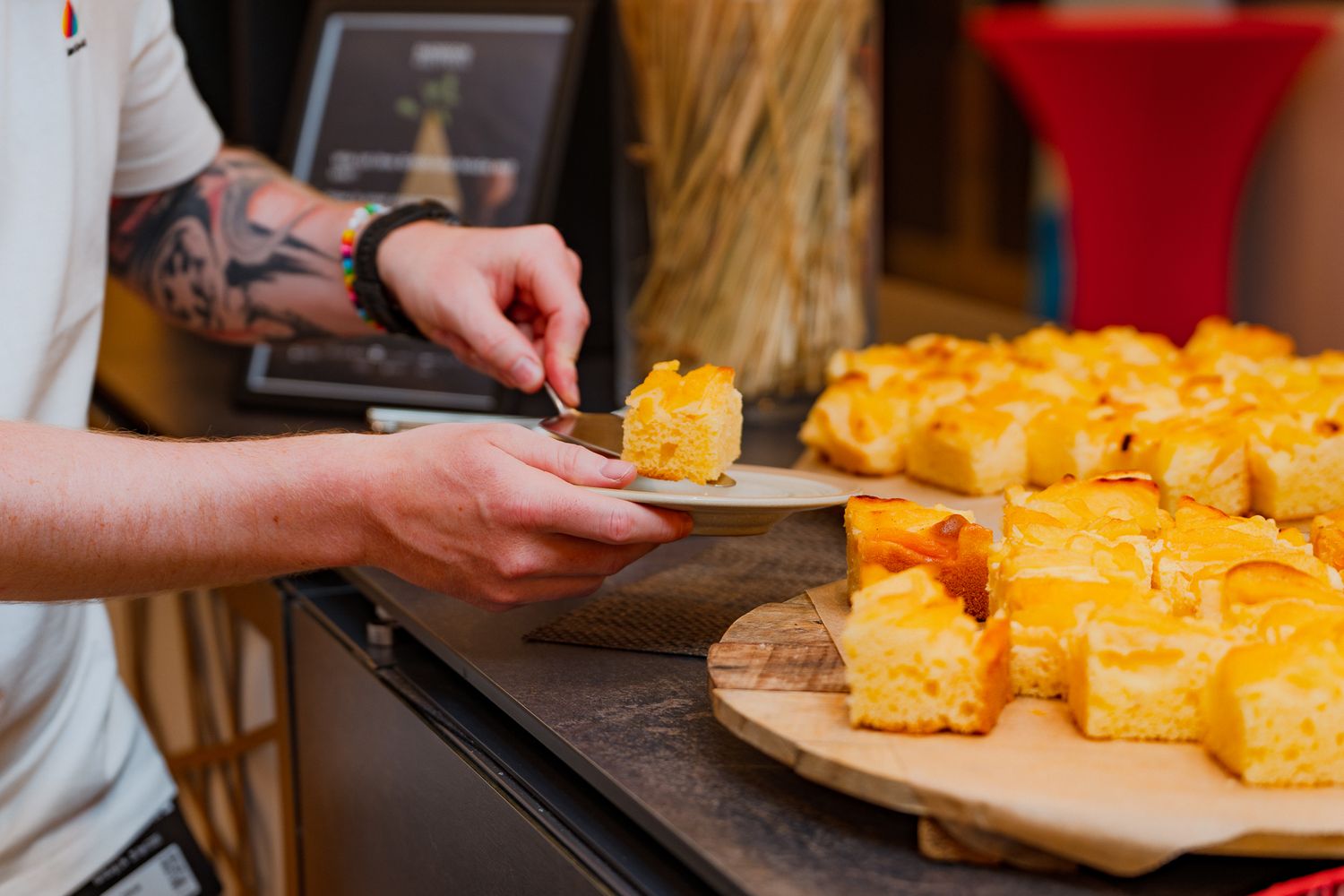 Ein Teilnehmer nimmt sich ein Stück Kuchen vom Konferenzbuffet