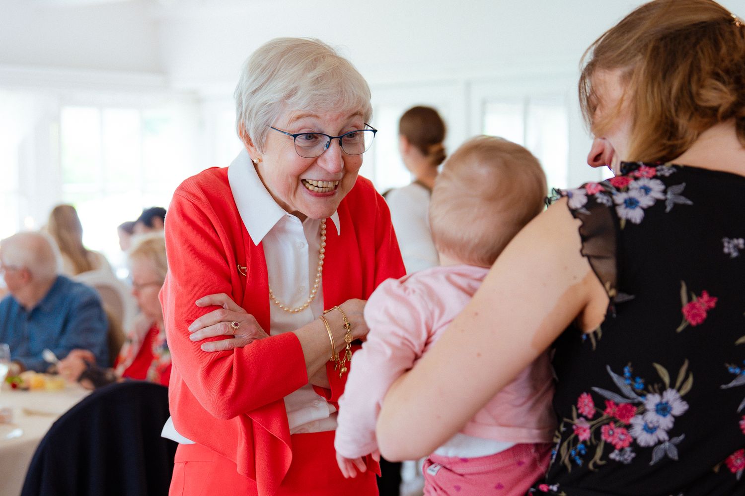 Eine ältere Frau spricht mit Kleinkind im Arm einer jungen Frau