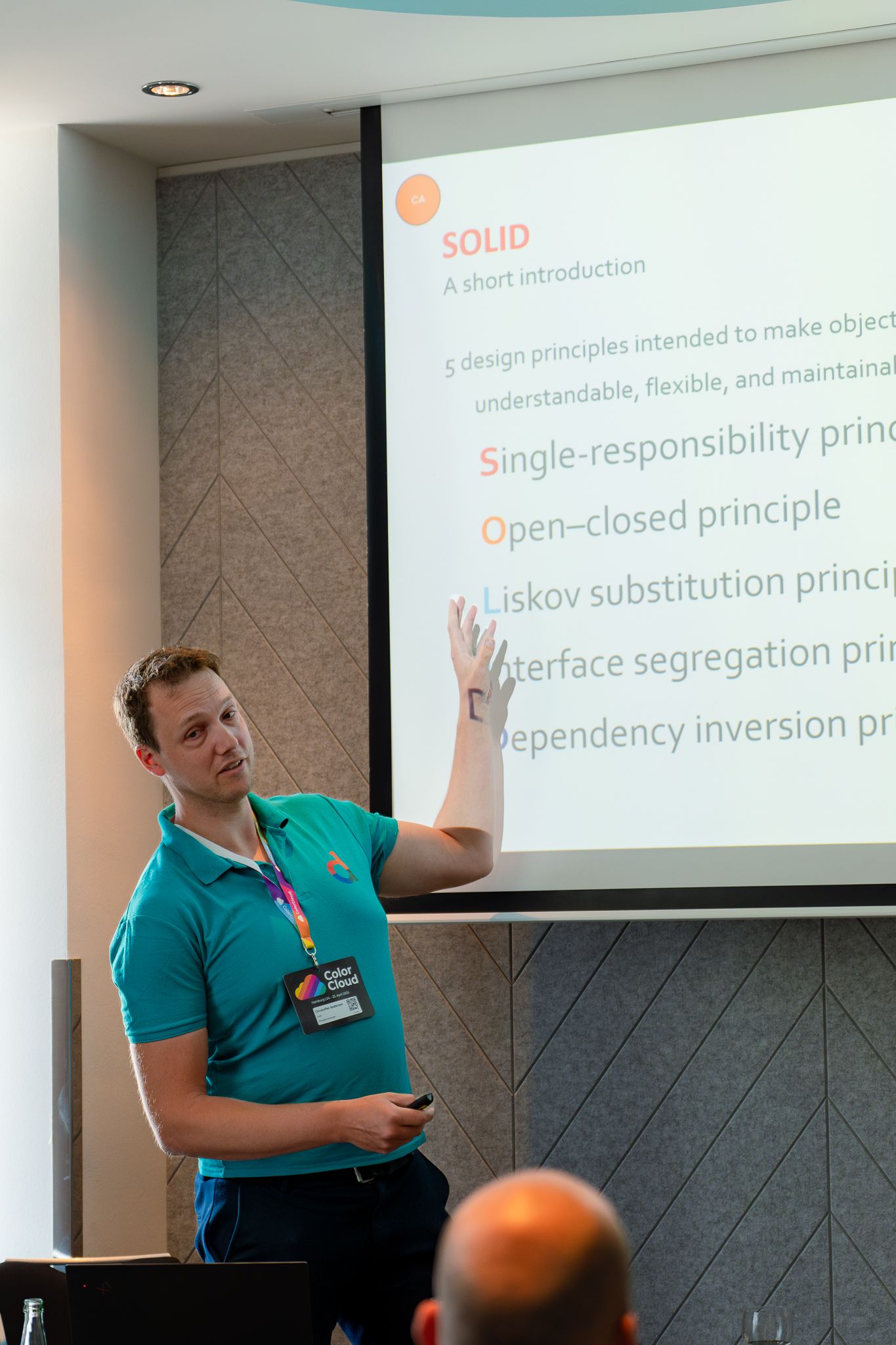Christoffer Andersen zeigt auf eine Leinwand während seines Vortrags auf der ColorCloud 2025