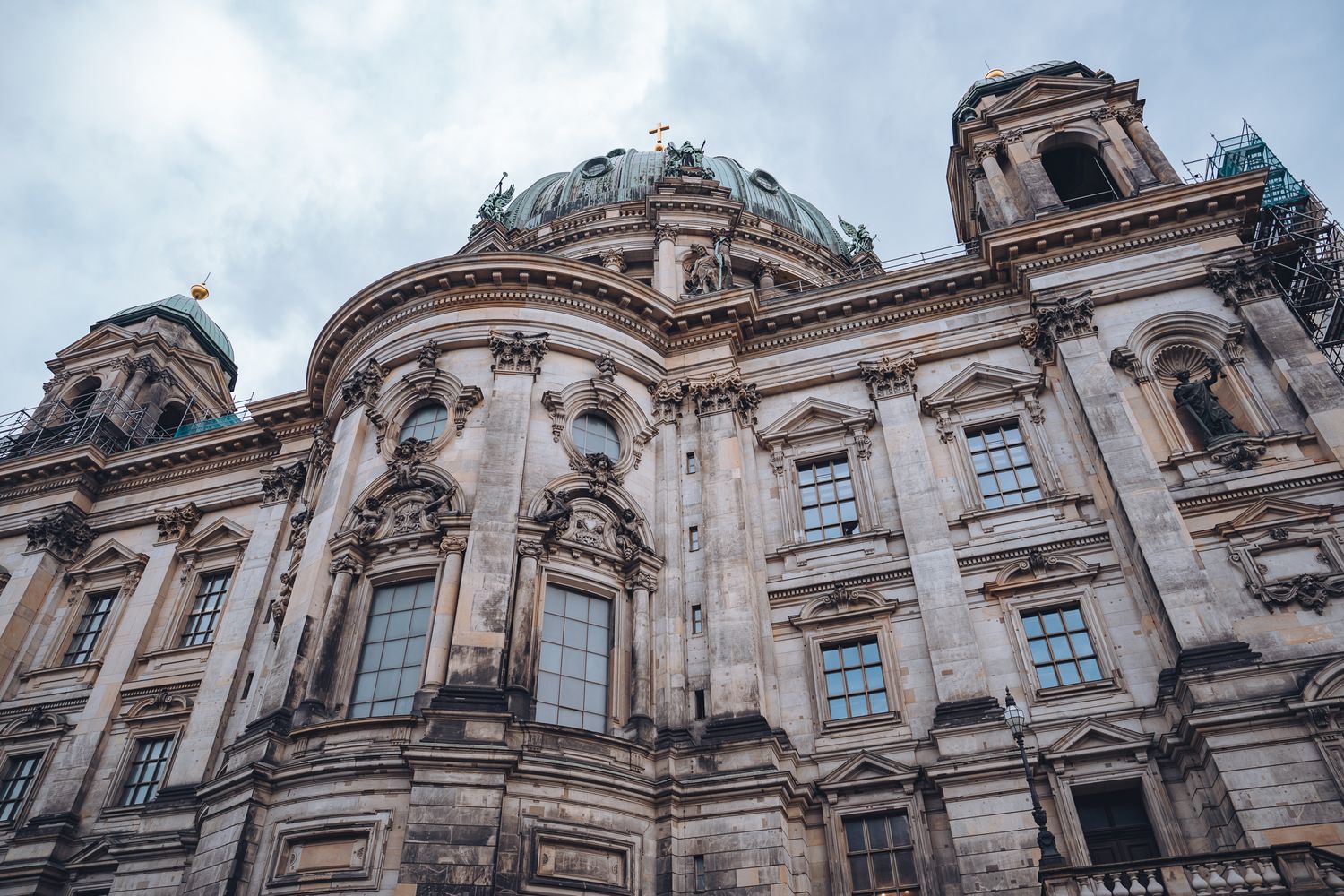 Detailansicht der Fassade des Berliner Doms mit Kuppel, Rundbögen, Skulpturen und steinernen Verzierungen