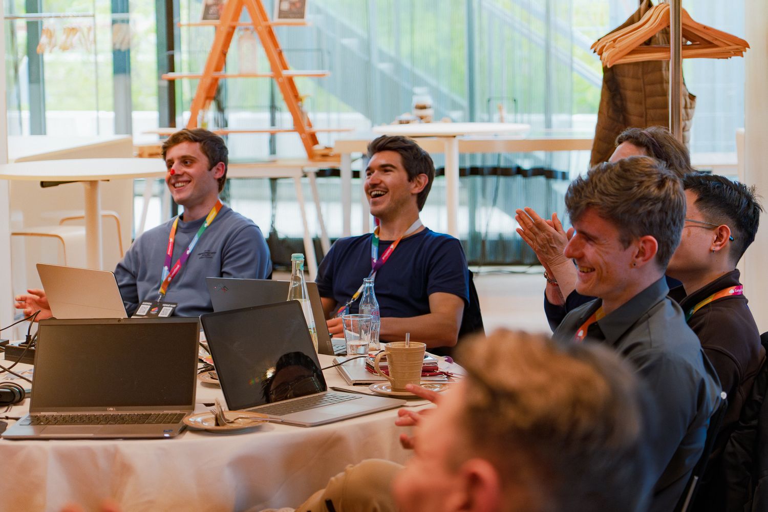 Teilnehmende am ColorCloud PromptAthon hören einer Präsentation zu und applaudieren