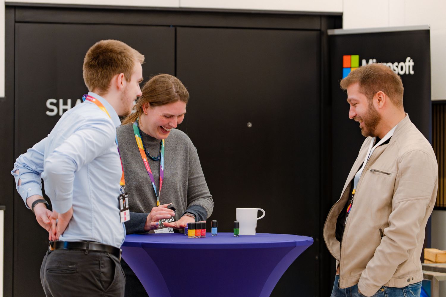 Eine Teilnehmerin der ColorCloud-Konferenz lackiert sich die Nägel, während zwei andere Teilnehmer ihr dabei zuschauen