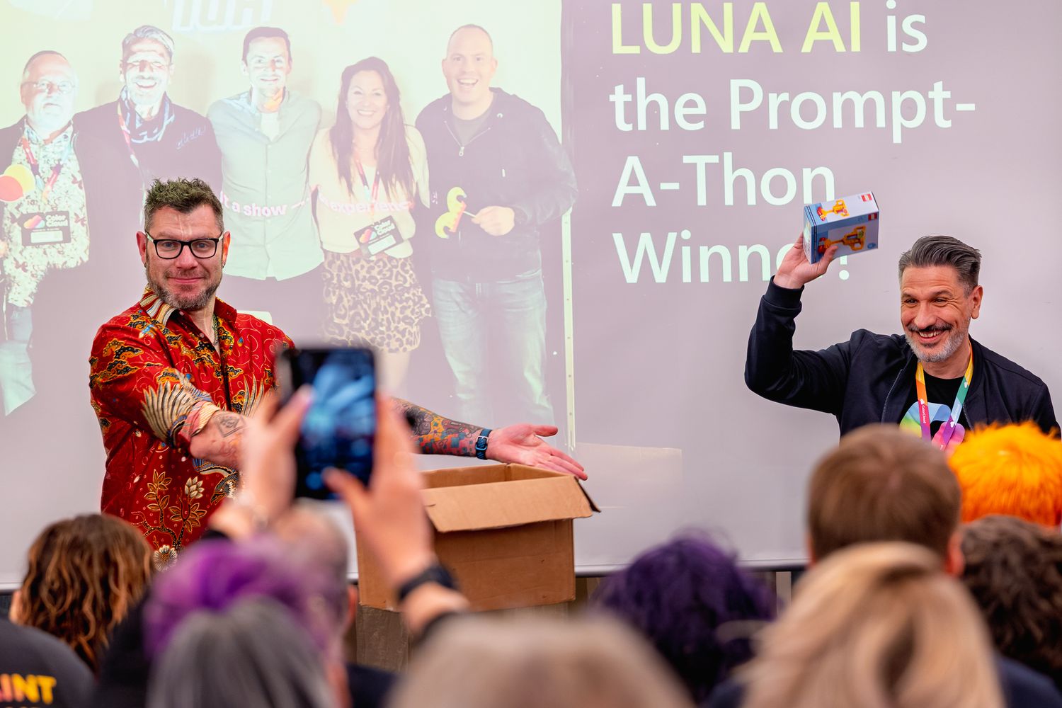 Chris Huntingford ehrt einen der Gewinner des ColorCloud PromptAthon, der seinen Preis, eine Lego-Verpackung, hochhält