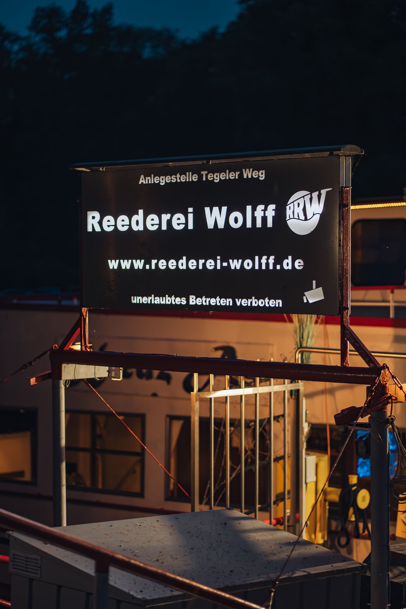 Das Schild der Reederei Wolff an der Anlegestelle Tegeler Weg bei Nacht
