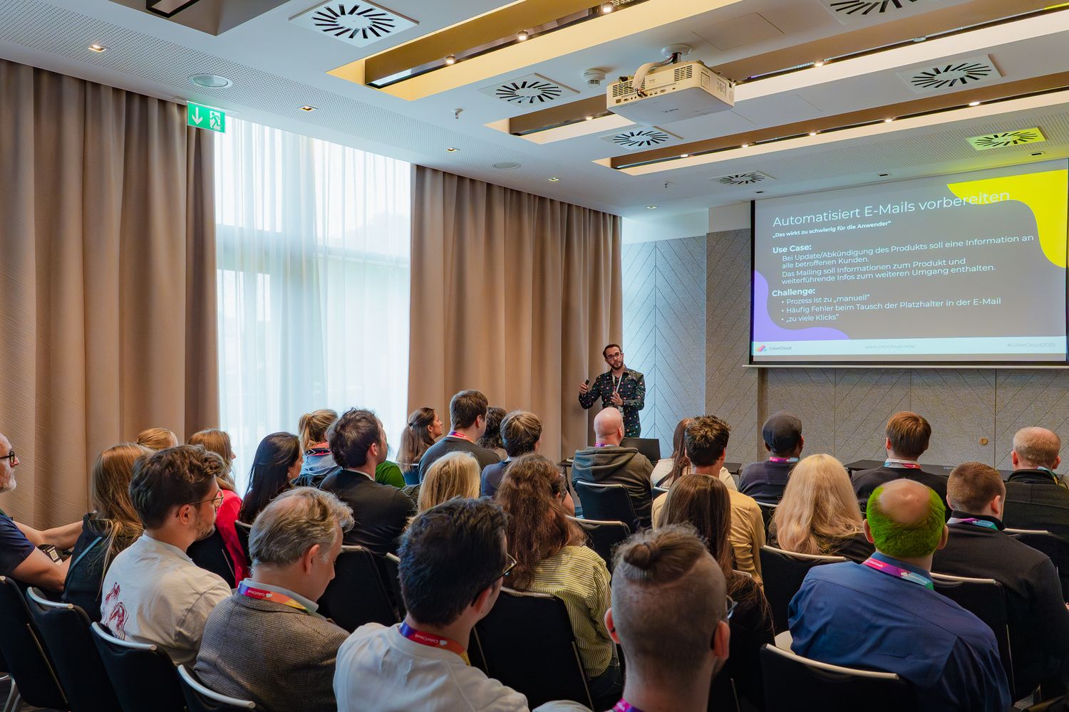 Dennis Istel hält eine Präsentation in einem gefüllten Seminarraum auf der ColorCloud-Konferenz