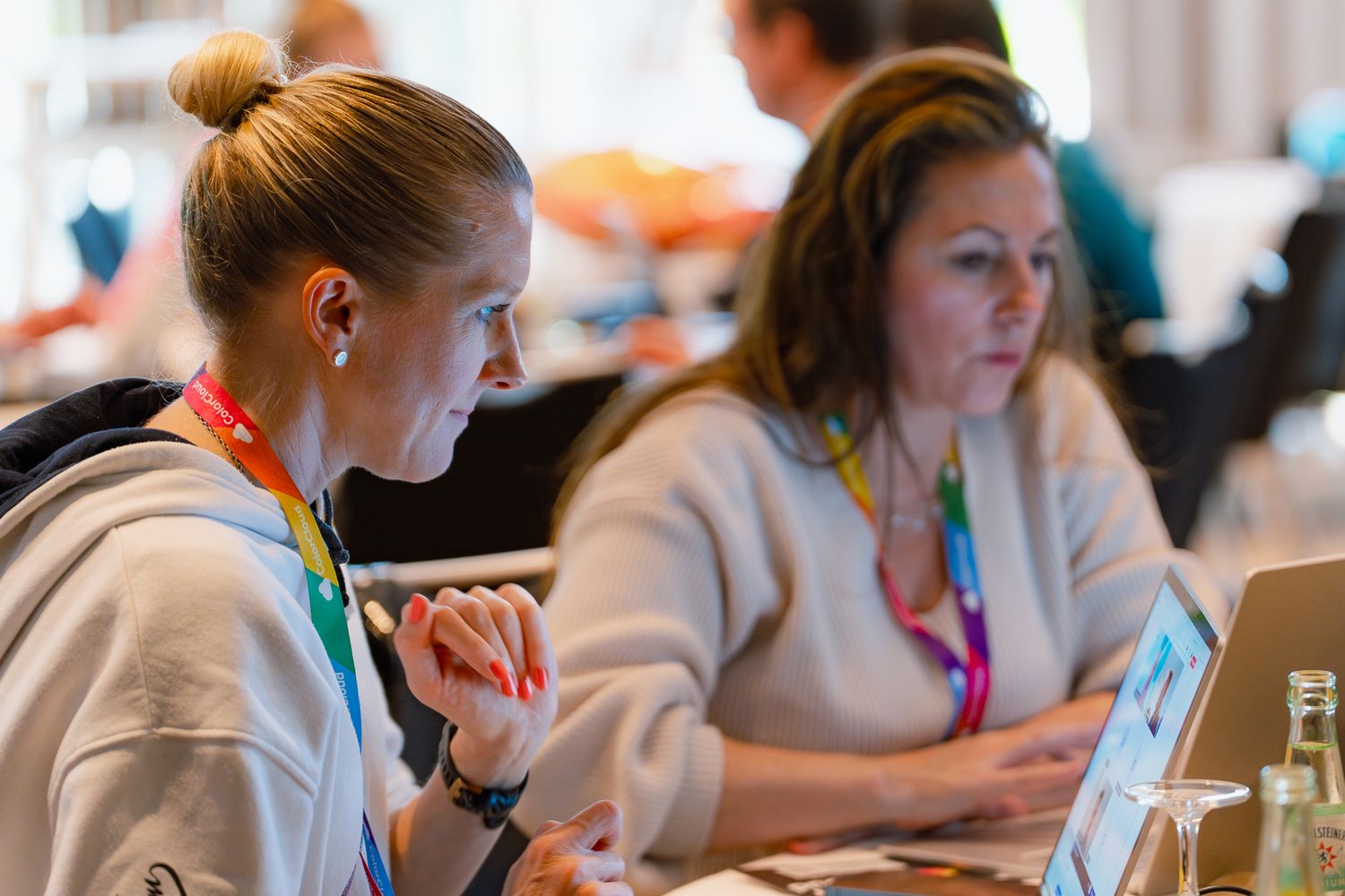 Zwei Teilnehmerinnen des ColorCloud PromptAthon arbeiten an ihren Laptops