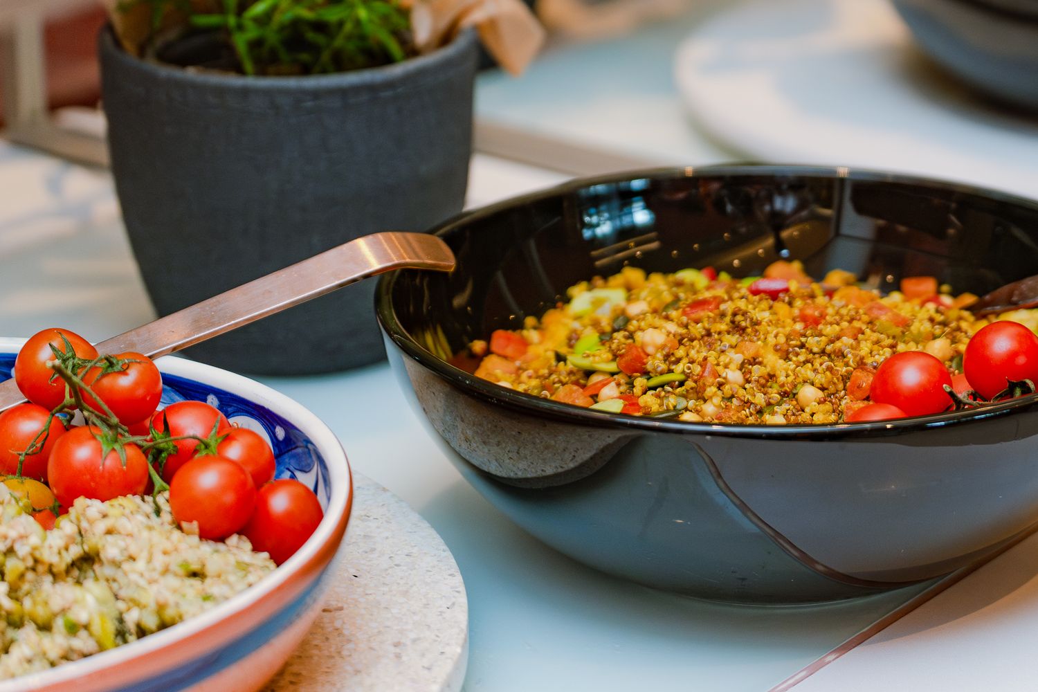 Bunte Bowls mit Tomaten und Getreidesalat am Buffet